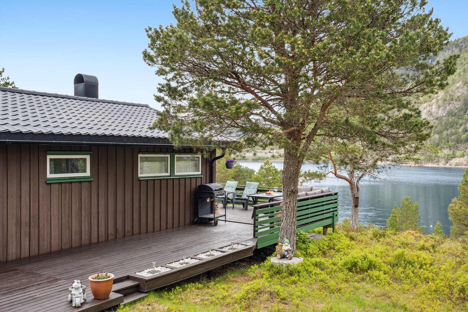 Tomten ligger fint til høyt oppe i terrenget med utsikt over fjord og sjø. Galleribilde