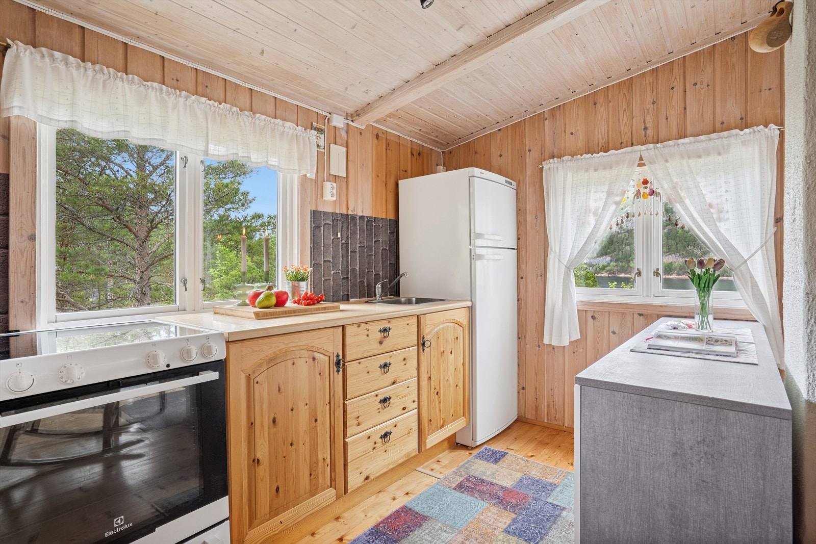 Kjøkkenet har en innredning med heltre skrog med profilerte fronter og laminert benkeplate. Galleribilde