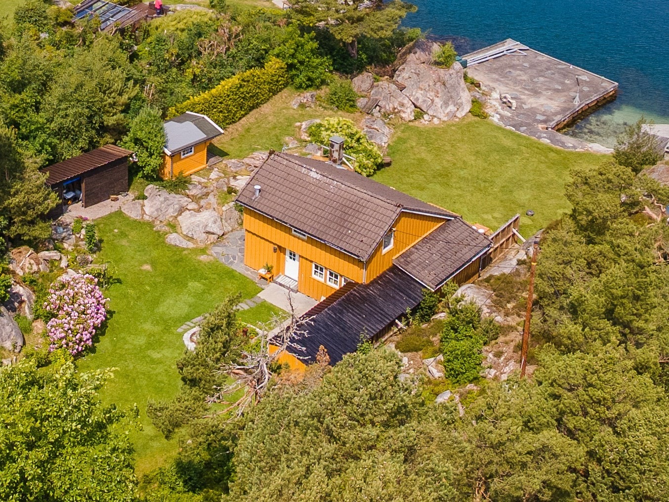 Usjenert, lun og solrik eiendom med masse boltreplass, flere soner, mulighet for båtplasser og ekstra tomt. Galleribilde
