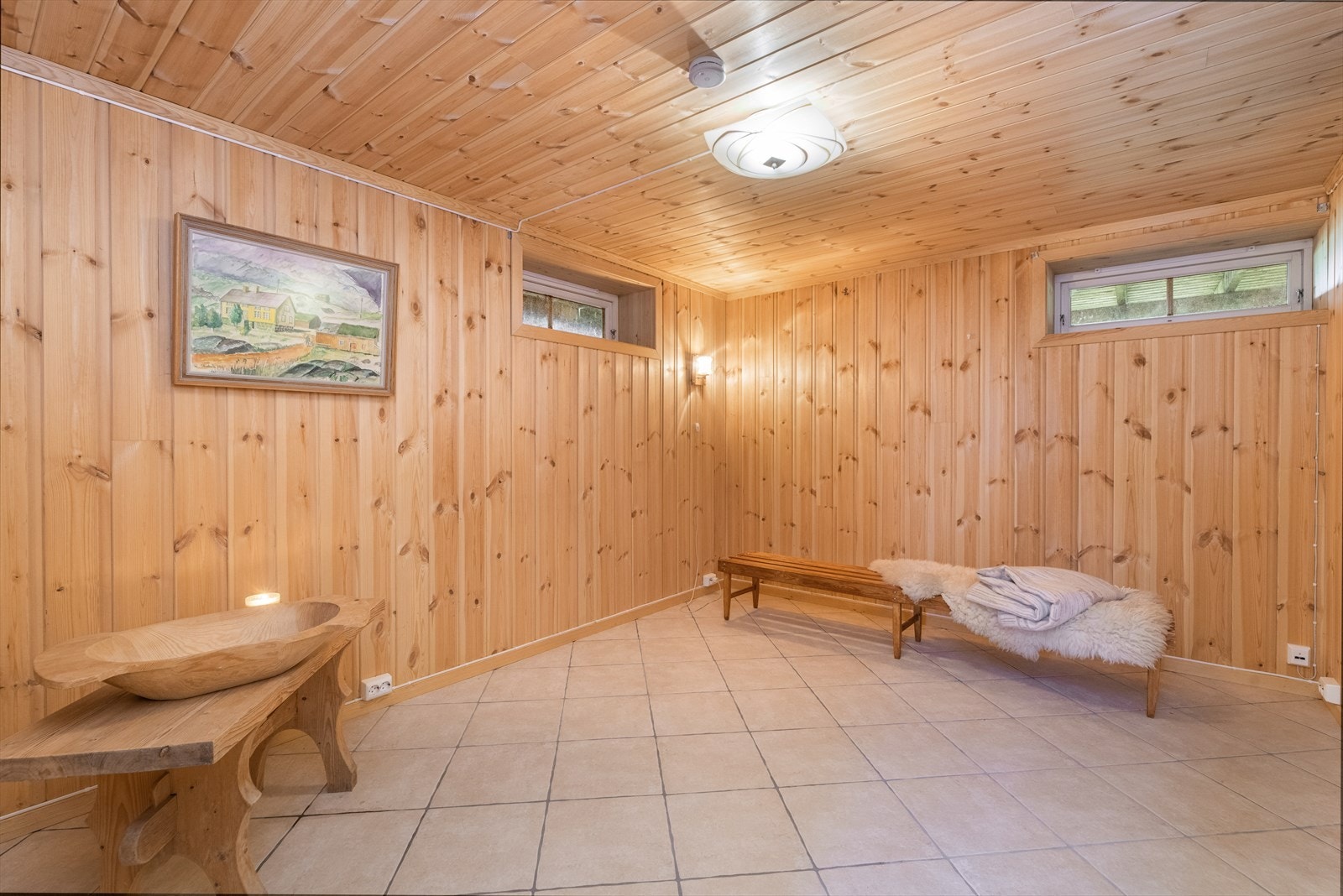 Kjellerstuen har flislagt gulv med varmekabler, med tilliggende badstue og dusjrom. På veggoverflater og i tak er det panel. Galleribilde