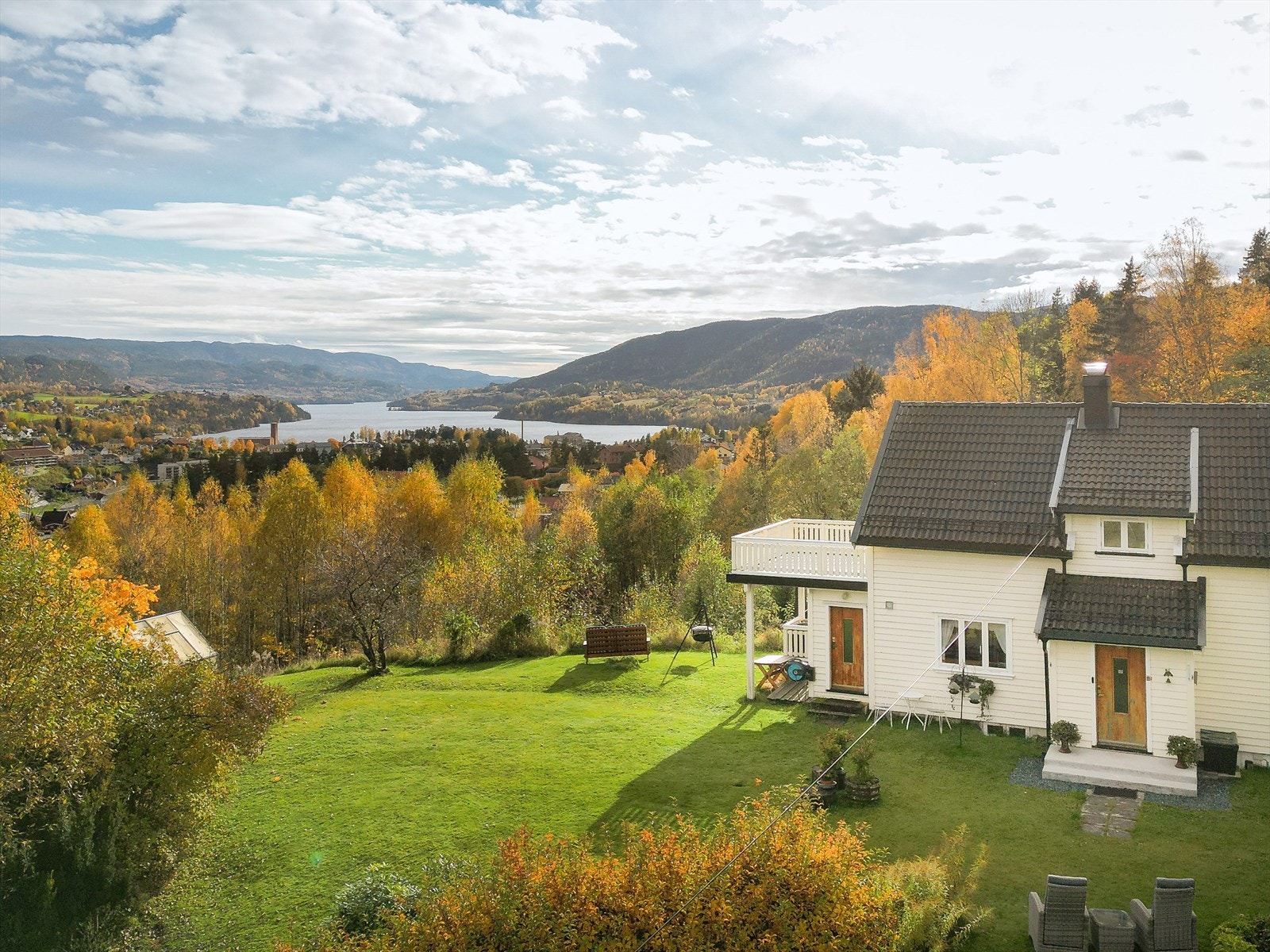 Idyll! Robotgressklipperen tar seg av plenen på tunområdet sommerstid. Galleribilde