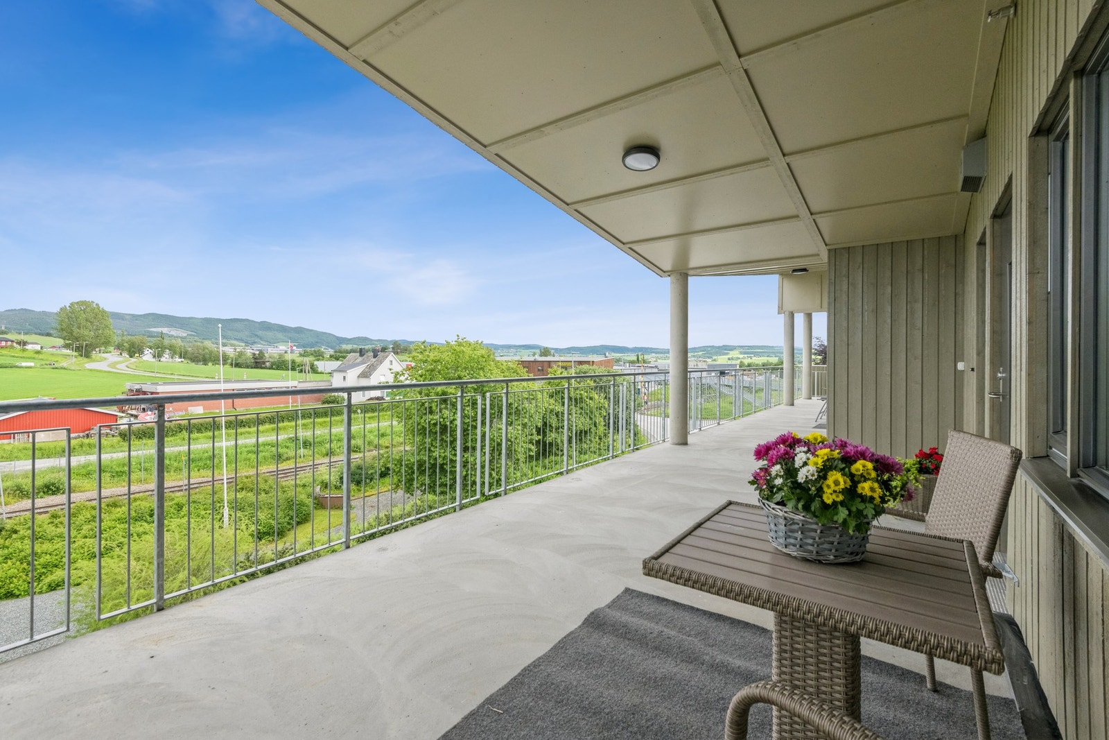 Romslig svalgang utenfor inngangsdøra med morgensol - perfekt for en rolig kaffestund før dagen starter. Galleribilde