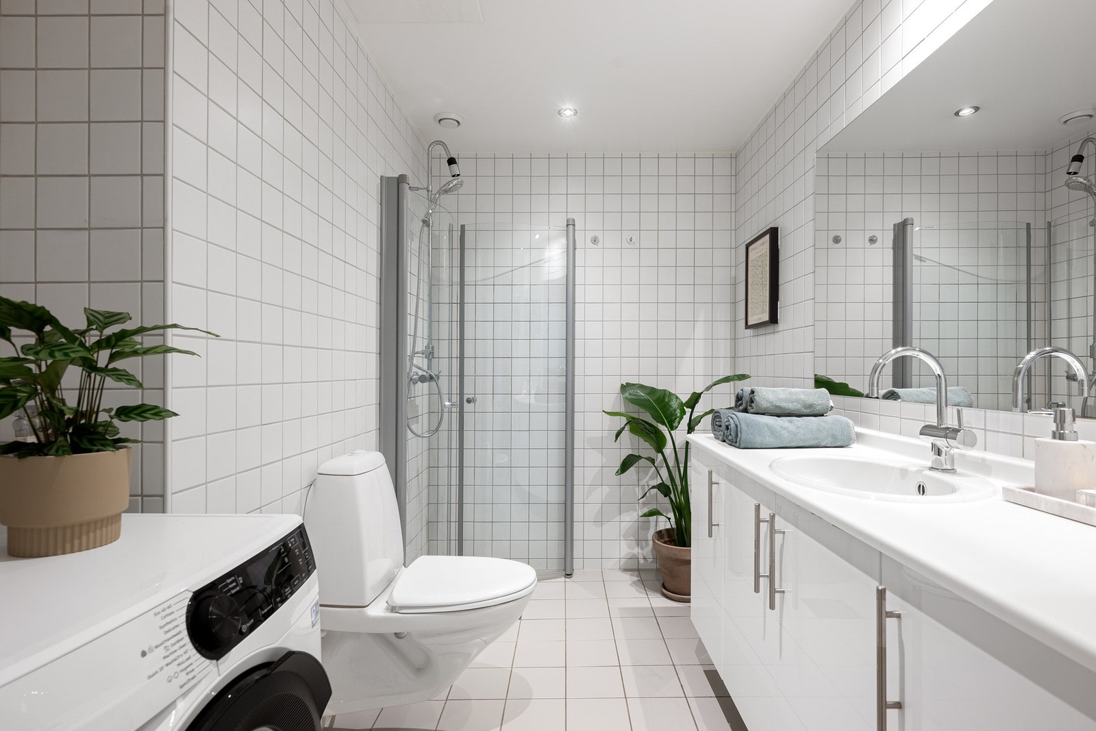 Flislagt bad med gulvvarme og opplegg for vaskemaskin. Galleribilde