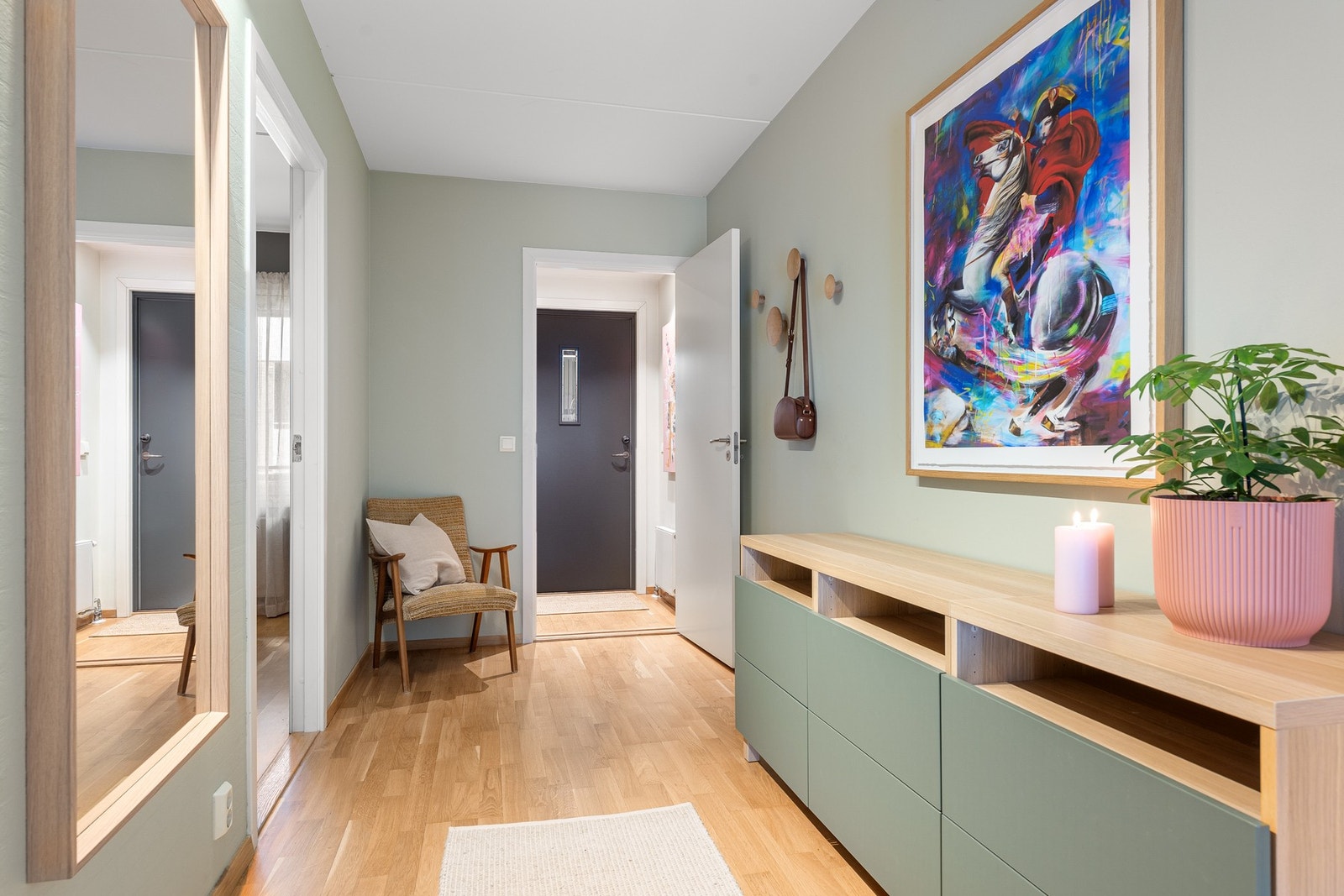 Leiligheten ønsker velkommen med en innbydende og funksjonell entré som setter tonen for resten av boligen. Galleribilde