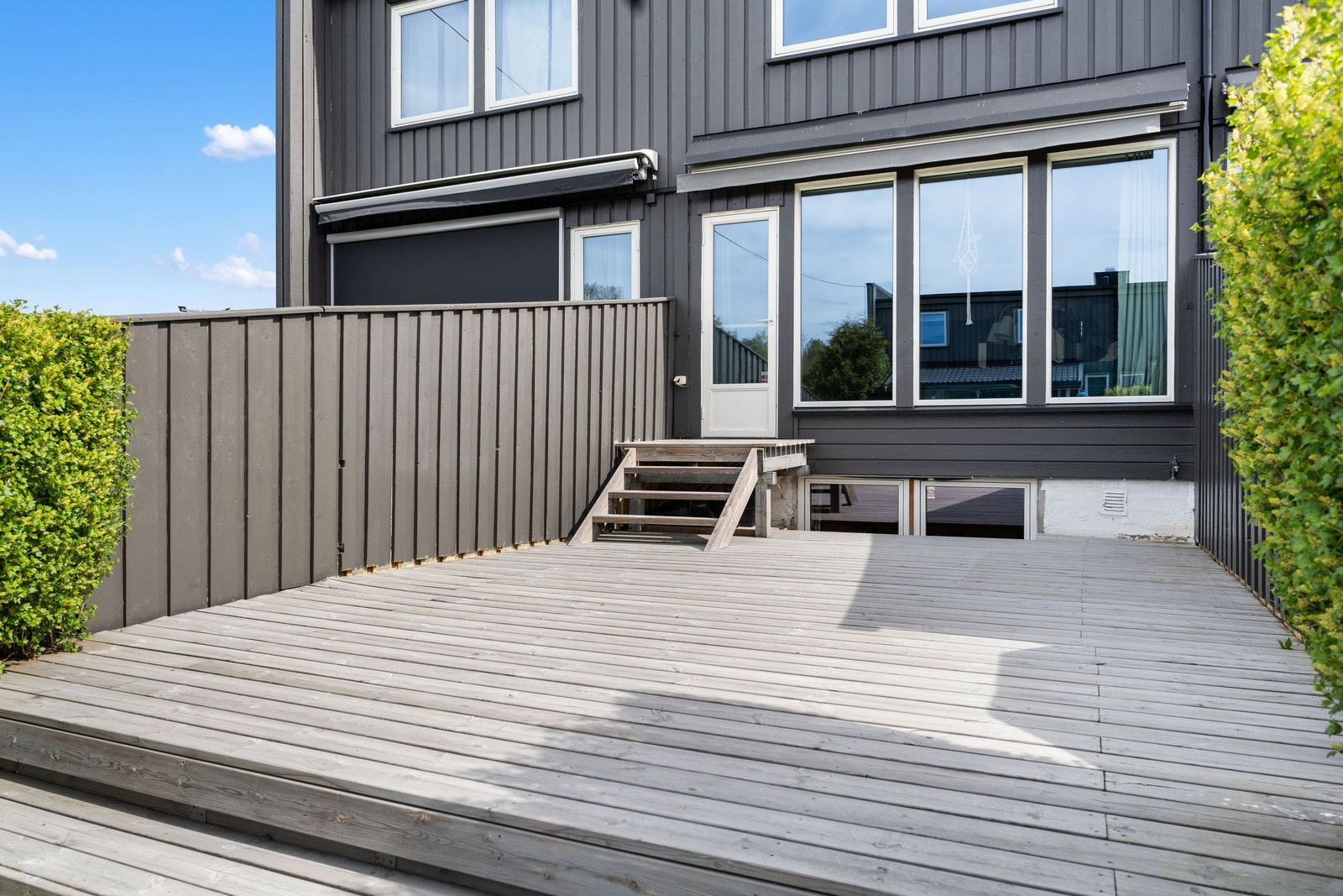 Hyggelig terrasse med god plass til utemøbler. Det er motorisk markise over deler av plattingen. Galleribilde