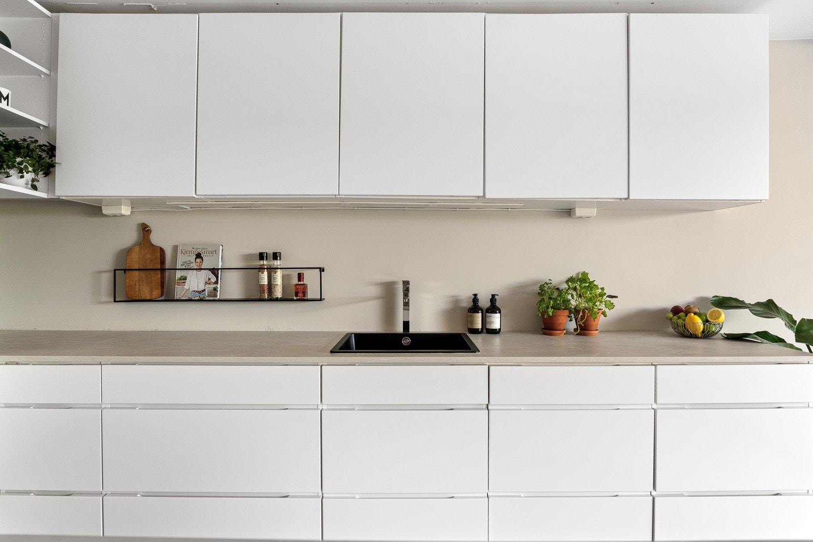 Lys laminat benkeplate med nedfelt sort komposittvask og ett-greps armatur i krom gir en fin kontrast og et elegant uttrykk Galleribilde