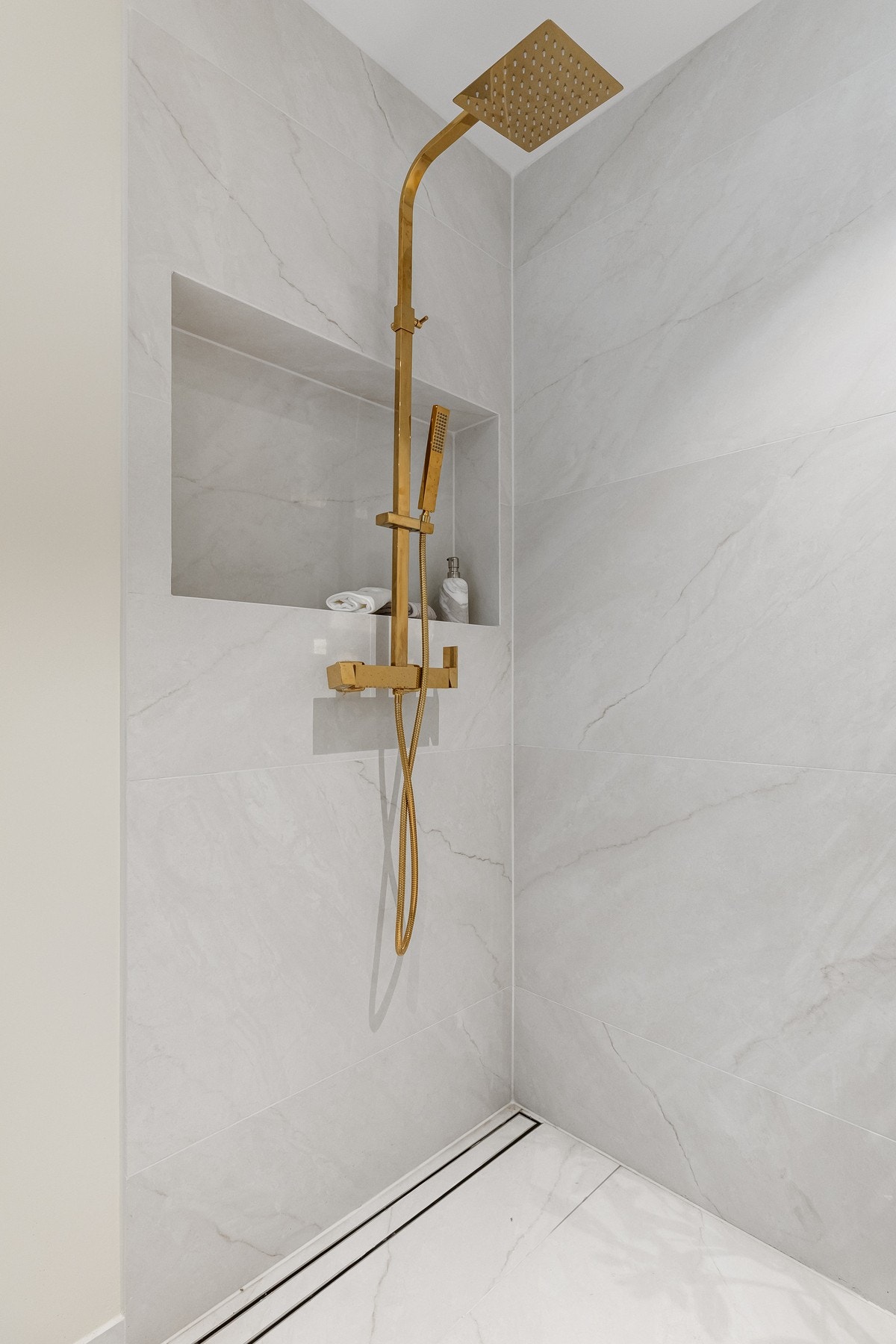 Purus Tile Insert slukrist og innfelt nisje i dusjsonen. Svært lekre armaturer i messing. Galleribilde