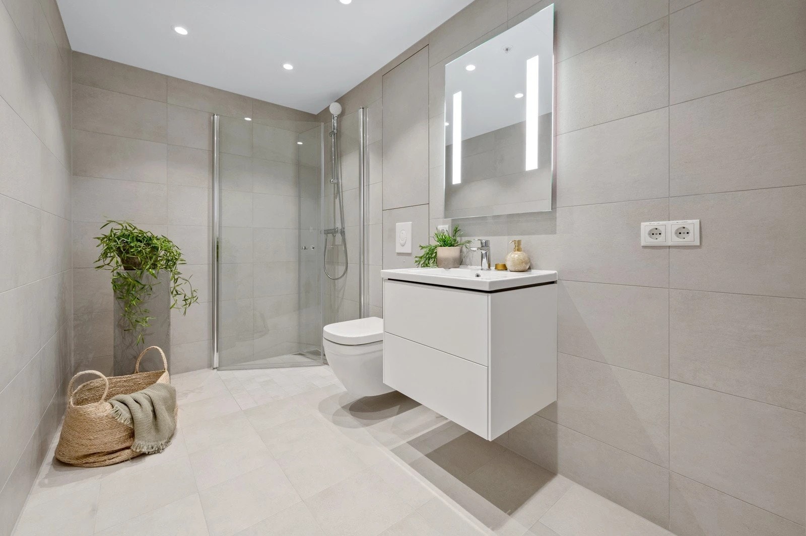 Stort flislagt bad med varmekabler, opplegg for vaskemaskin og tørketrommel Galleribilde