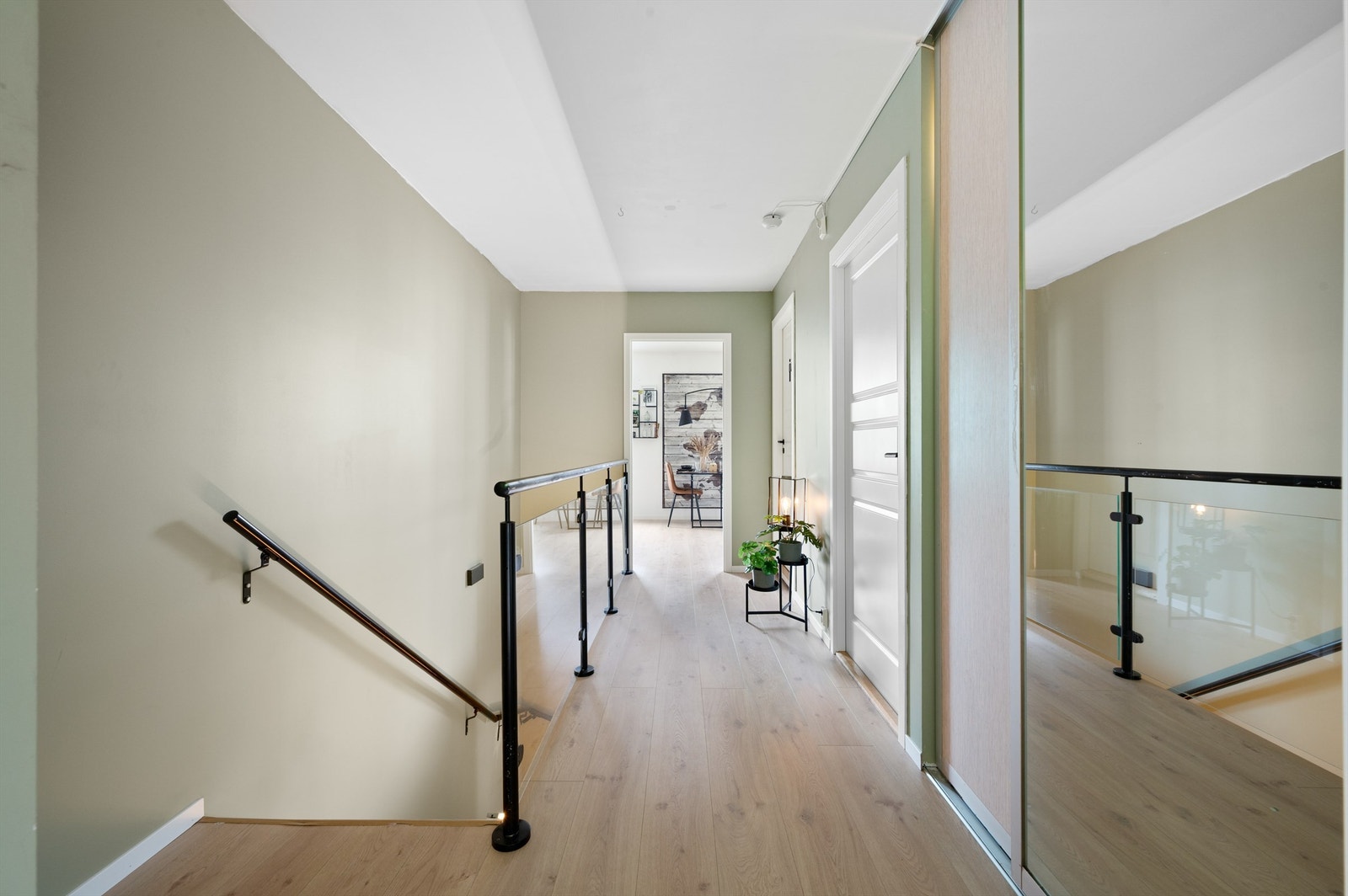 Fra stue kommer vi til en romslig gang med entré og tilgang til bad og soverom 1. Flott innredet med glassrekkverk og skyvedørsgarderobe. Galleribilde