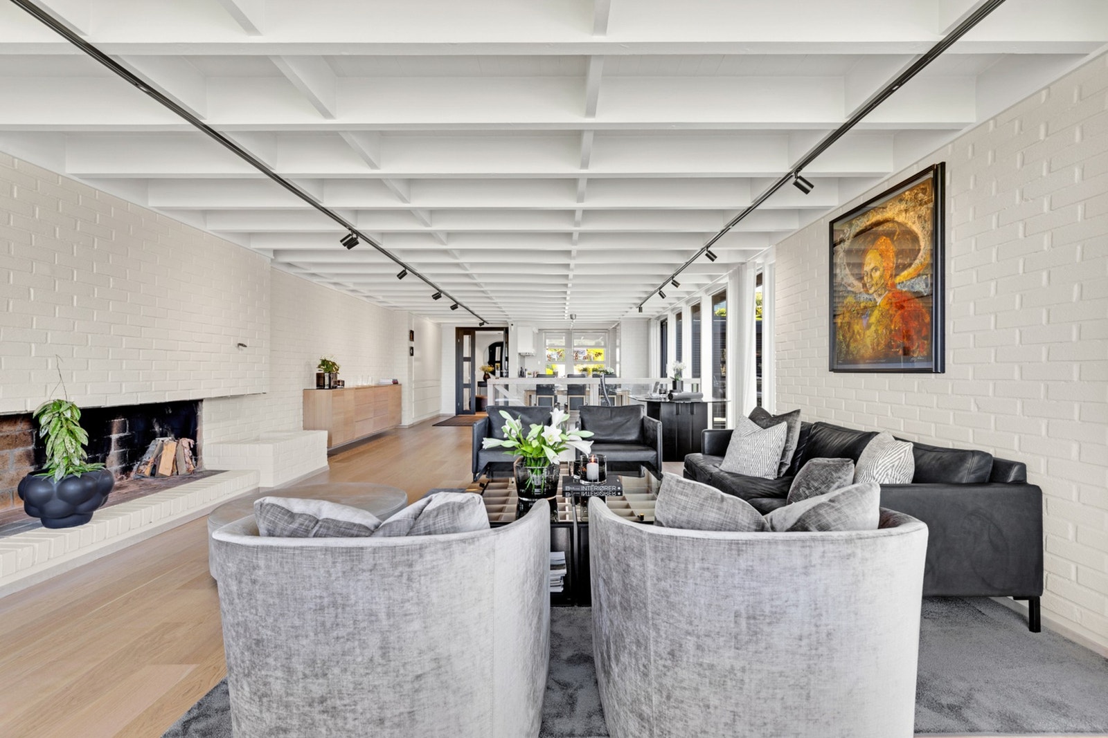 Bjelkene i taket og de lyse murveggene gir stuen og boligen særpreg. Galleribilde