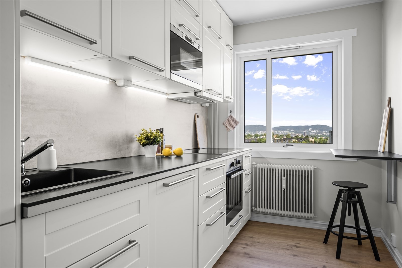 Kjøkkenet ligger adskilt fra stue med plass til et lite frokostbord. Galleribilde