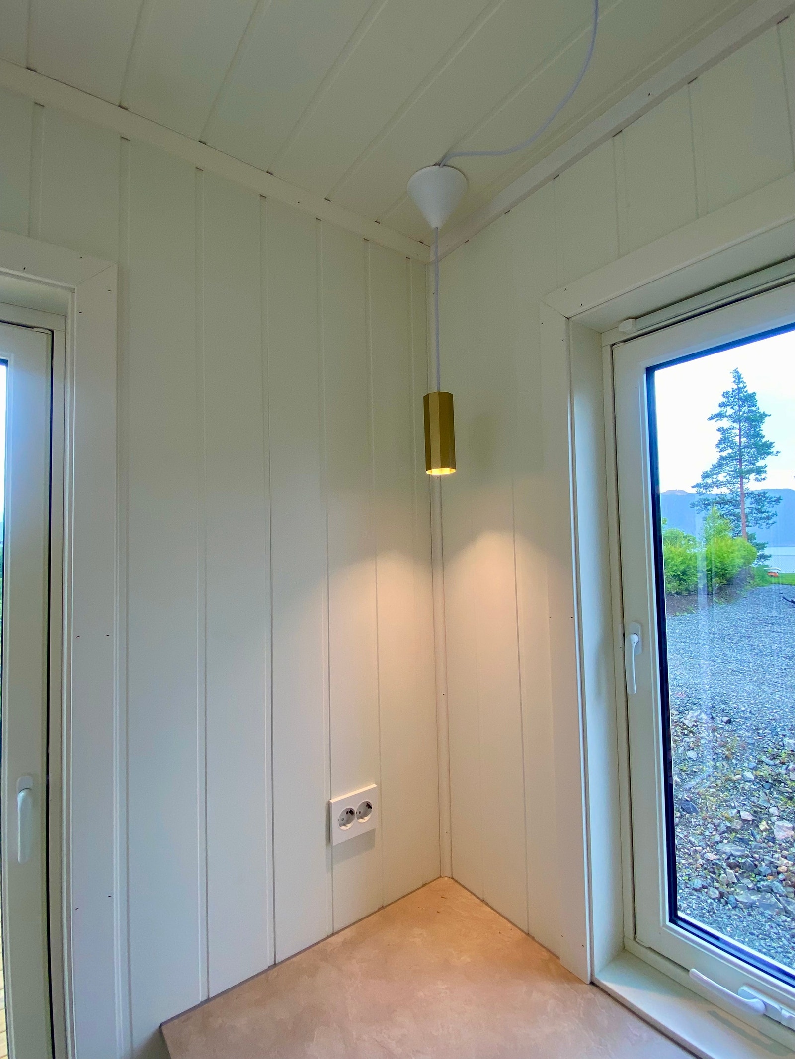 Stemningsfull pendel over kjøkken benken i tidsriktig messing som tar opp håndtakene på kjøkkenet. Galleribilde