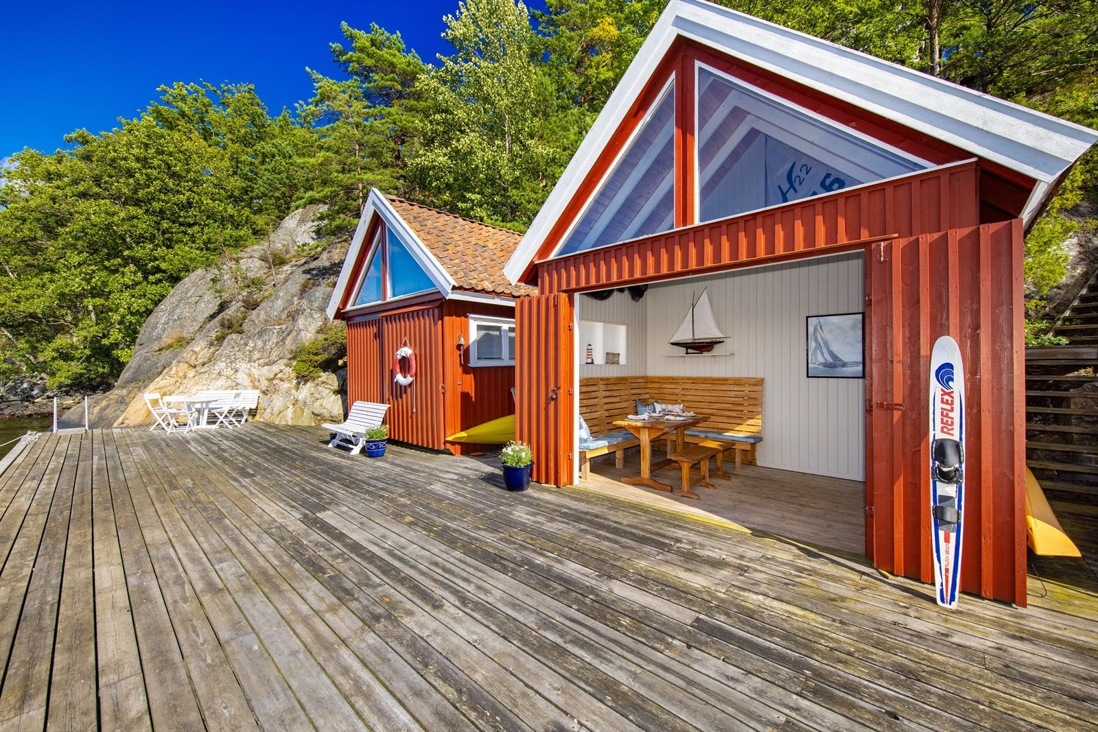 Naust med store doble dører som kan åpnes ut mot sjøen. Galleribilde