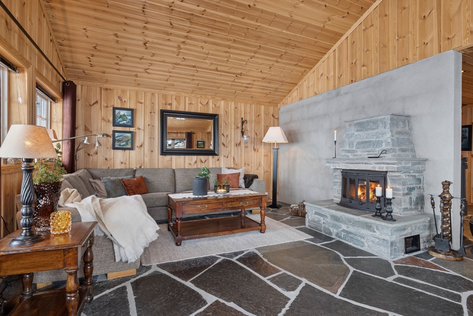 Rommet har åpen himling noe som gir ekstra takhøyde, og bidrar til en herlig, luftig atmosfære. Videre har stuen skifergulv med vannbåren varme, panelvegger og panelt himling. Galleribilde