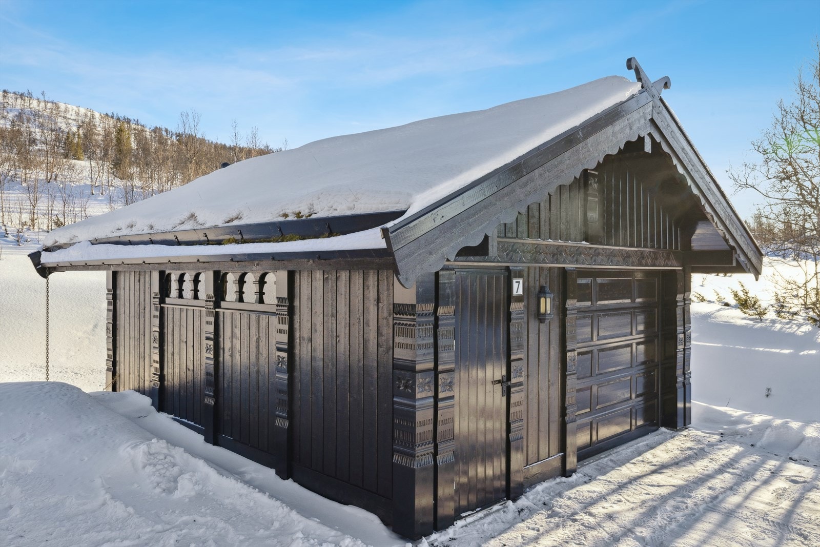 Garasjen få meter fra hytta - et sikrer snøfritt kjøretøy og et praktisk lagringssted for alt fra verktøy til utendørsutstyr. Det er egen bod i tilkyttning til garasje - det perfekte smørerom. Galleribilde