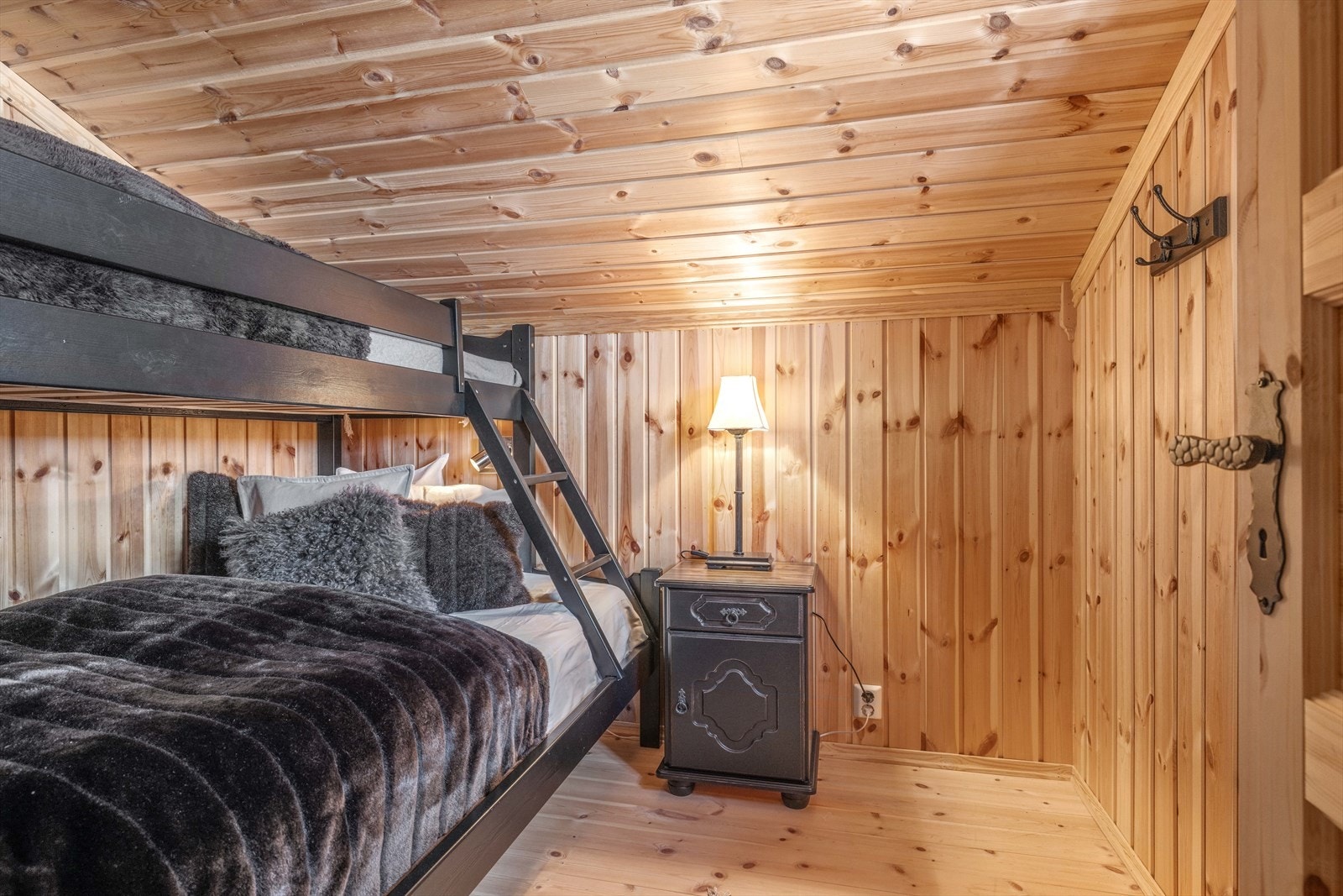 Hyttas fjerde soverom ligger andre etasje. Dette soverommet er av noe mindre størrelse men perfekt til gjester eller kontor. Rommet er innredet med familiekøye. Panelte vegger og himling. Tregulv. Galleribilde