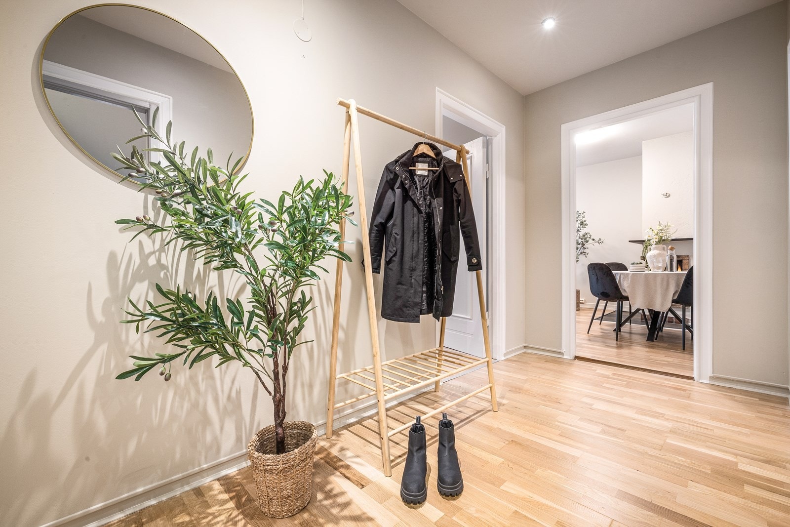 Lys entré med plass til oppheng av tøy og et lite skap for annen oppbevaring. Galleribilde