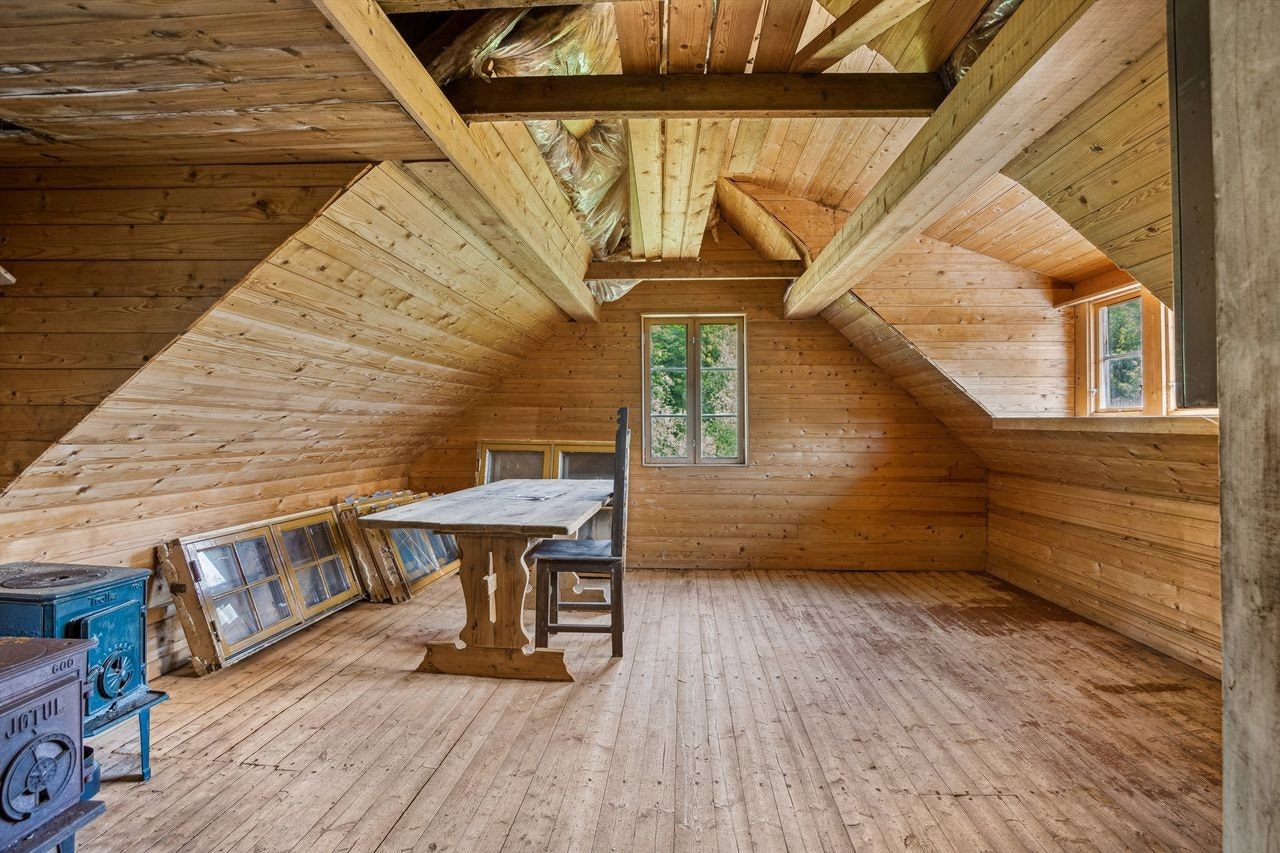I andre etasje finner du en koselig loftstue med varierende takhøyde fra 100 til 240 cm, som gir rommet en unik karakter. Her er det installert en vedovn som sørger for god varme og en hyggelig atmosfære. Rommet gir også adkomst til en praktisk bod. Galleribilde