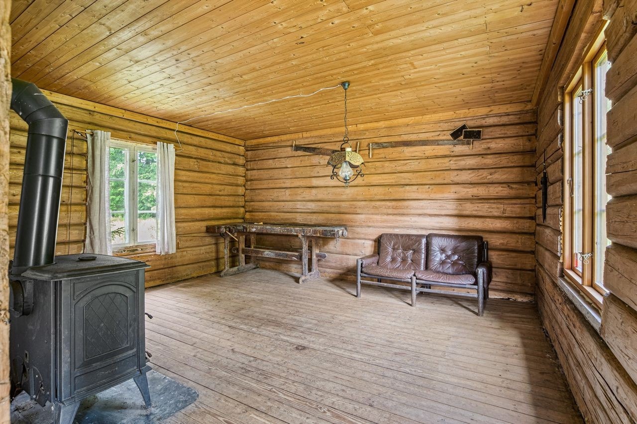 Stuen i første har en takhøyde på 240 cm, som gir en luftig atmosfære. Her kan du enkelt innrede en koselig sofakrok og spiseplass. En vedovn bidrar til en god varme på kjølige dager. Galleribilde