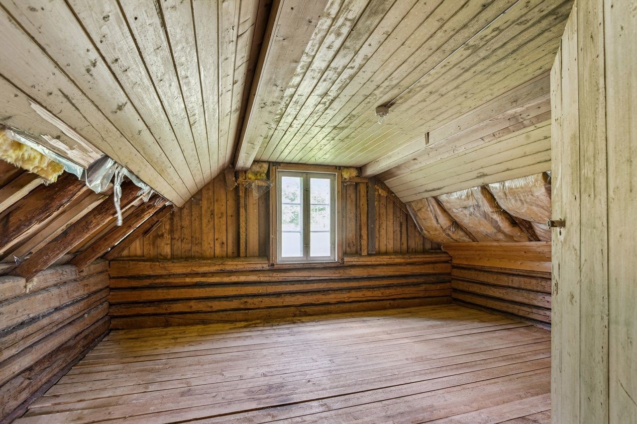 Dette uinnredede rommet i andre etasje gir et stort potensial for fremtidig utvikling. Rommet er for tiden uferdig og under oppussing, med synlig isolasjon og undertak, samt gulvsponplater. Her er det også installert en vedovn. Galleribilde