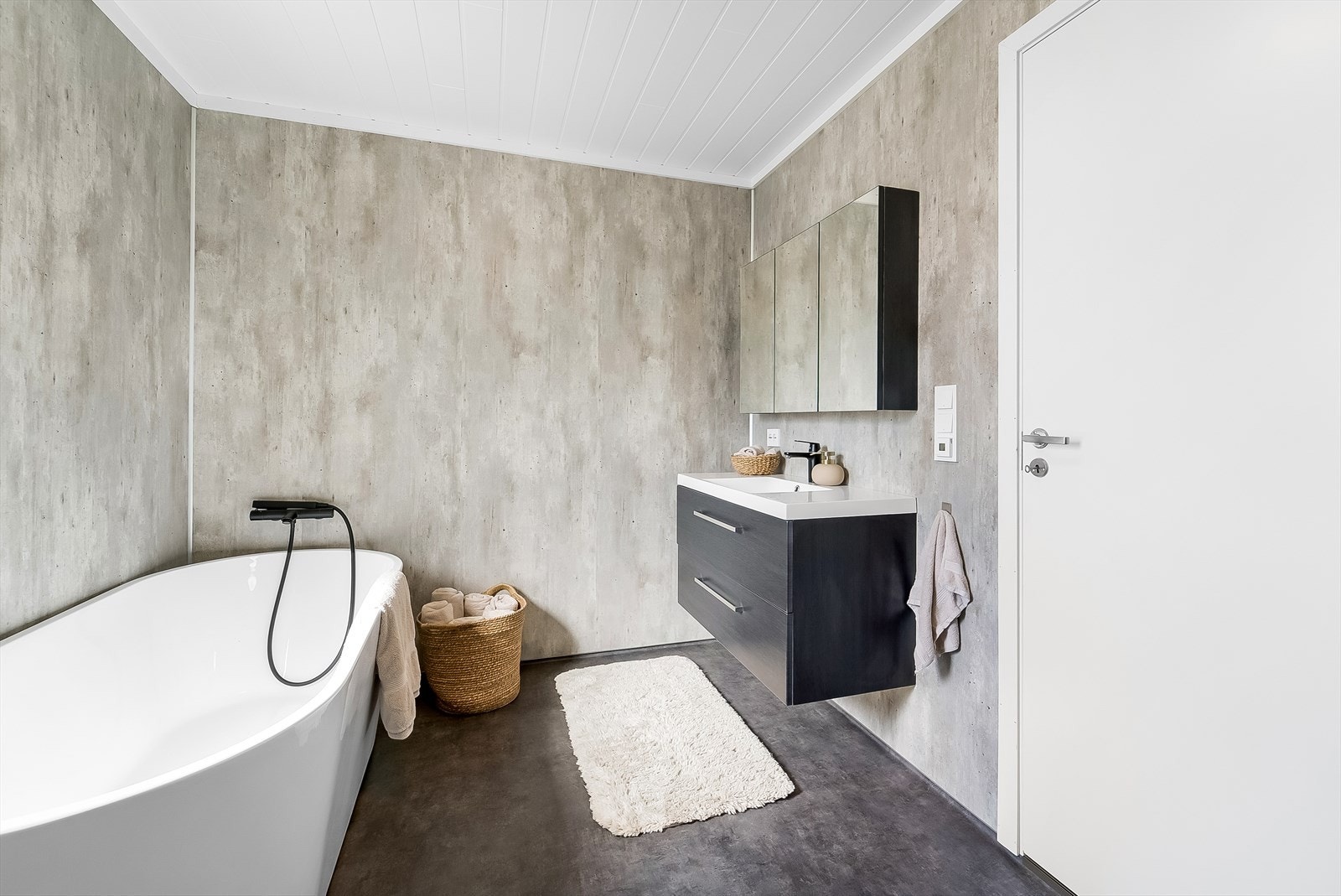 Tidløst innredet bad med baderomsinnredning, toalett, dusjkabinett og badekar. Galleribilde