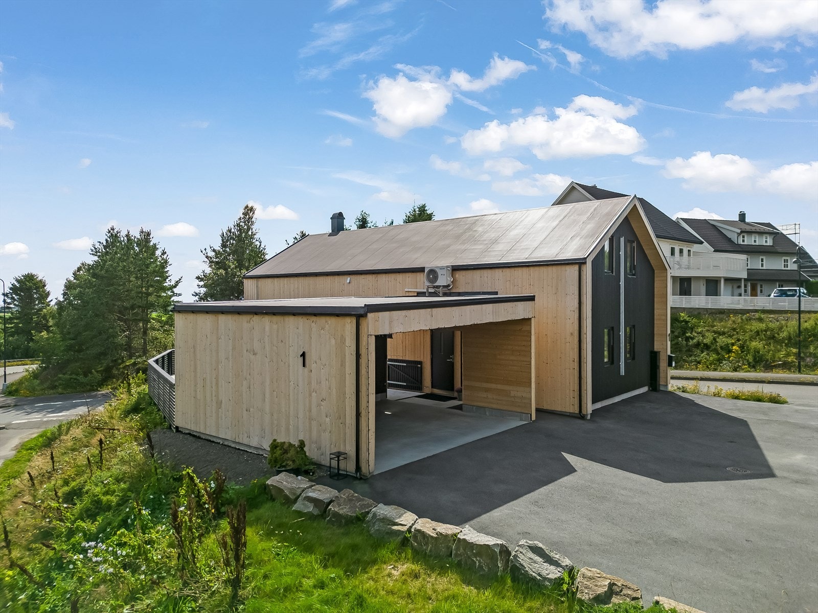 Eiendommen er omkranset av asfaltert uteområde og stor terrasse. Galleribilde