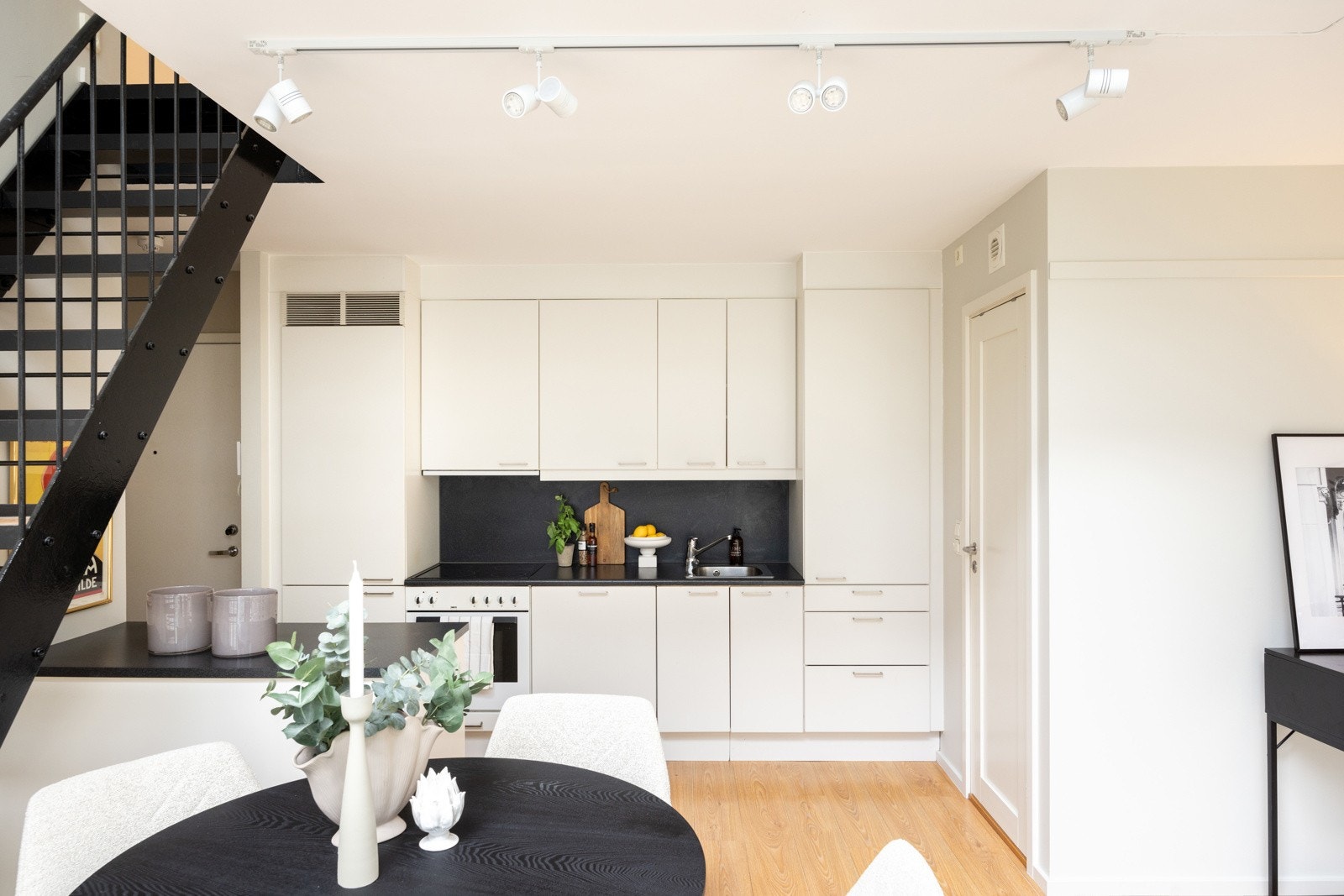 Innredningen på kjøkkenet består av hvite glatte fronter og laminat benkeplate Galleribilde