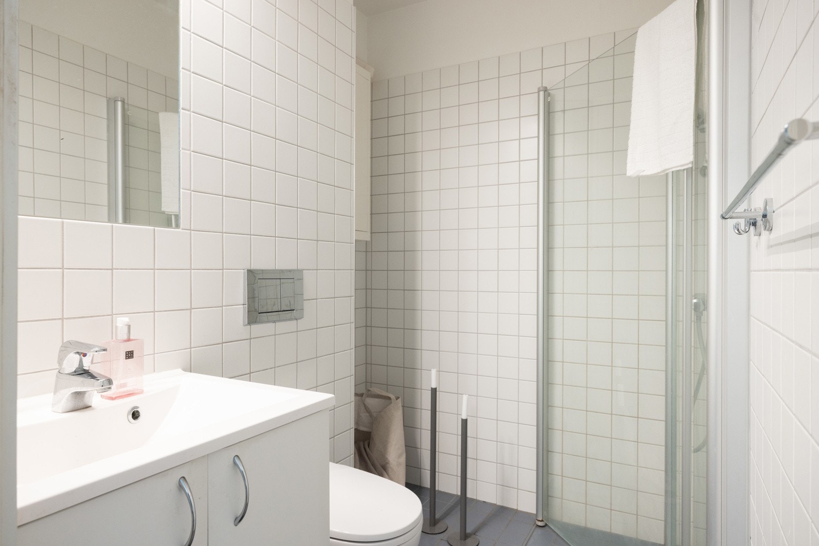 Badet i andre etasje er fra byggeår og har innredning bestående av vegghengt WC, dusjsone med svingbare glassdører og enkel servant Galleribilde