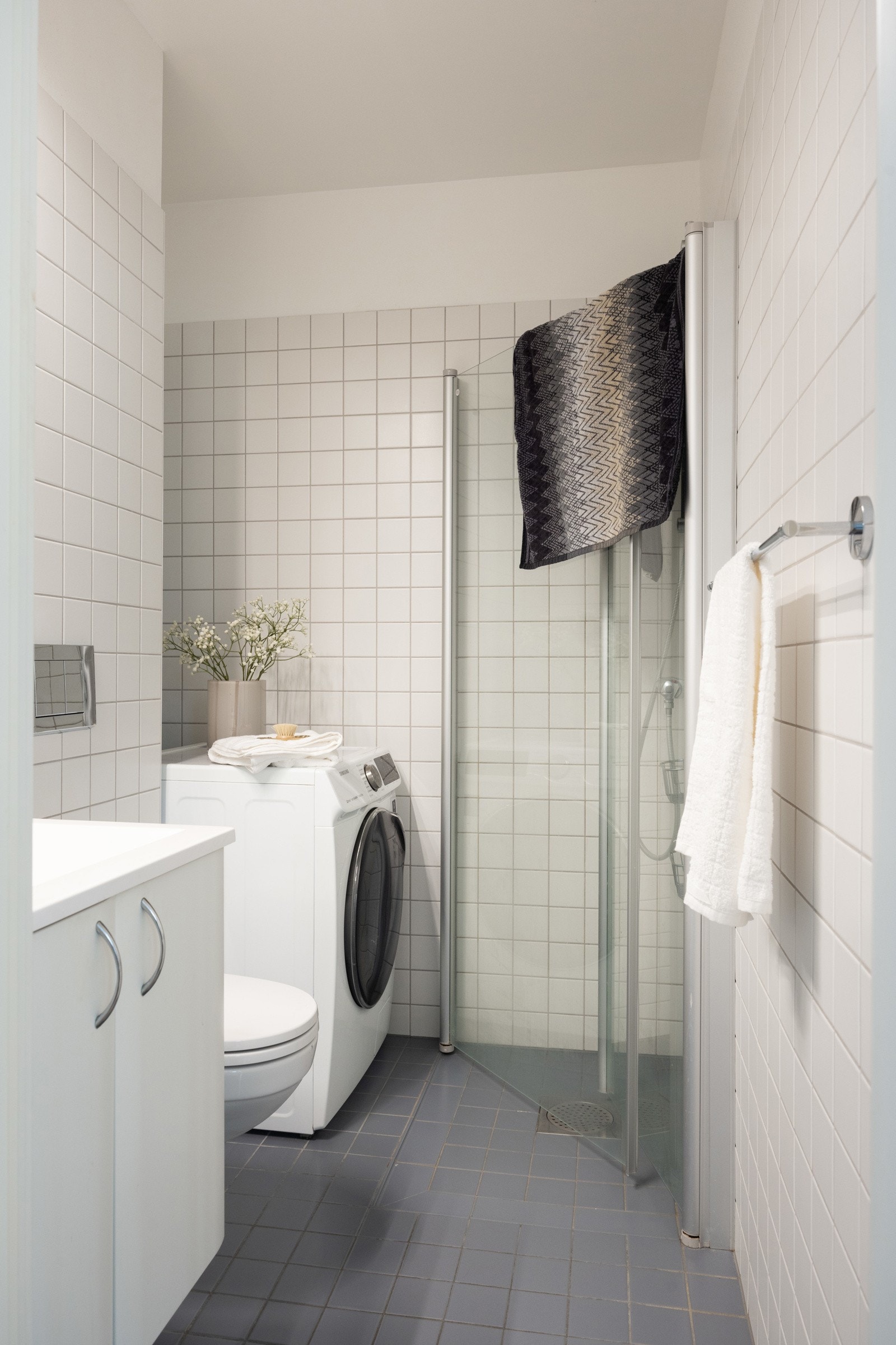 Badet er fra byggeår og har innredning bestående av vegghengt WC, dusj med svingbare glassdører og enkel servant Galleribilde