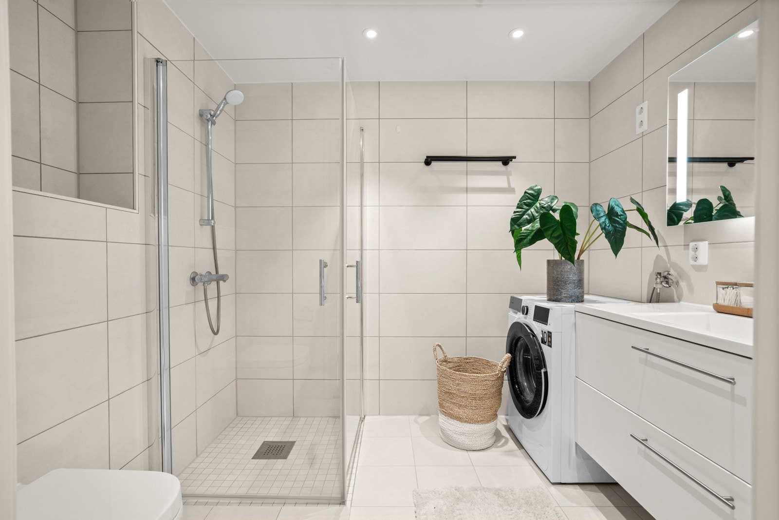 Delikat baderom med gulvvarme og opplegg for vaskemaskin Galleribilde