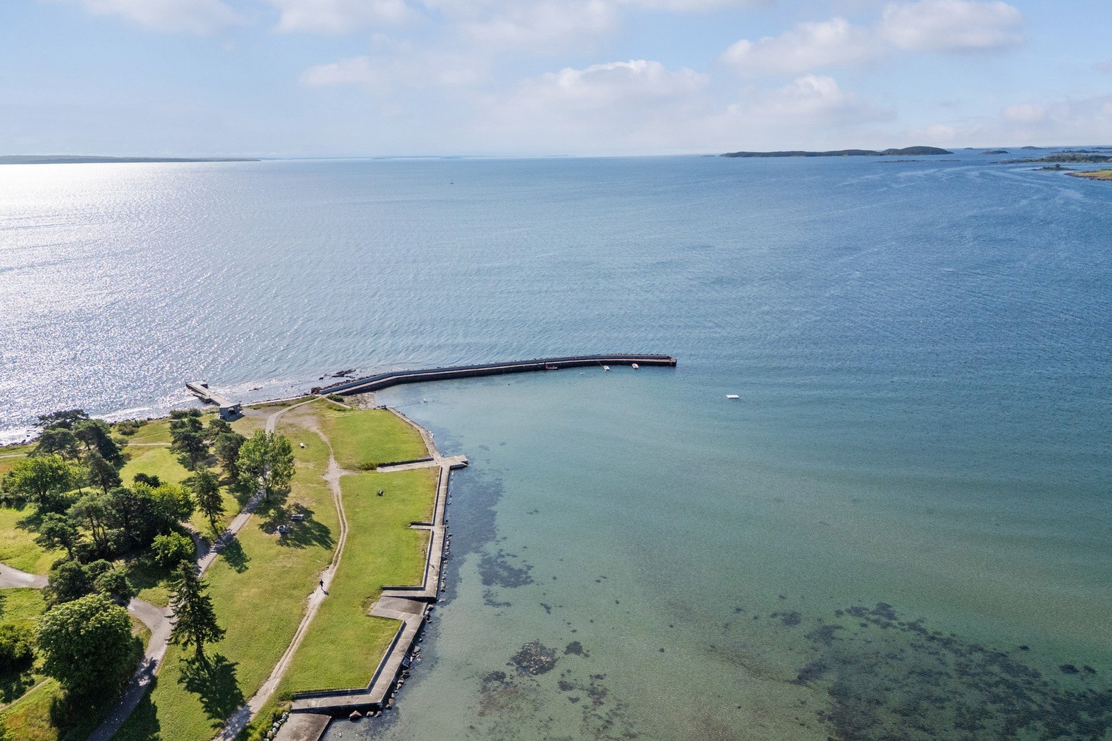 Stranden har steinmolo med badetrapp og stupemuligheter. Galleribilde