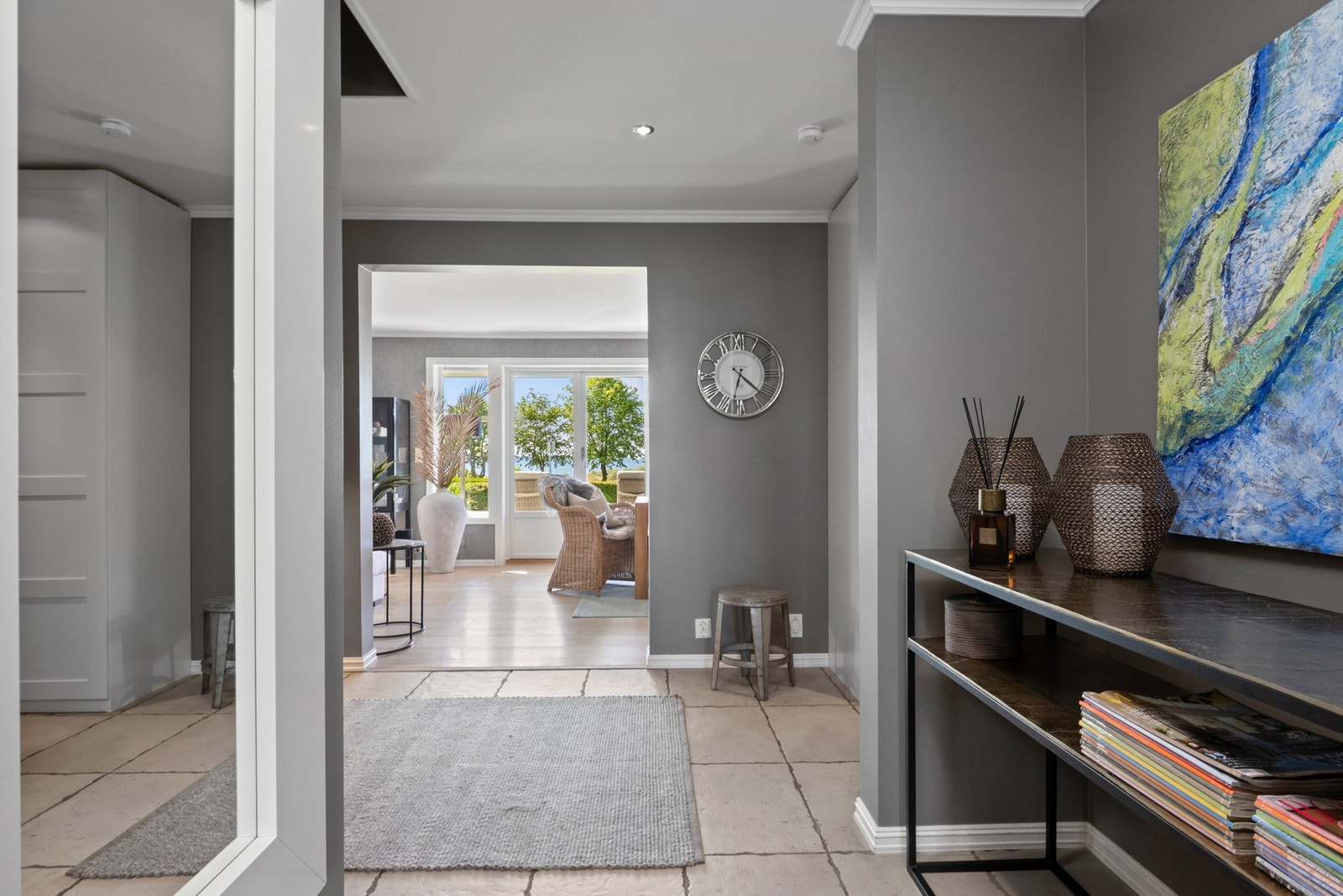 Entreen glir sømløst over i en hall med downlights i taket, innredet med samme type skap og overflater. Galleribilde