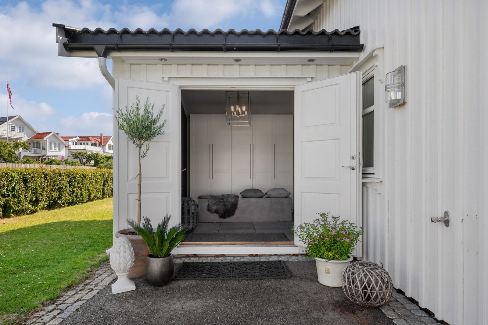 Ytterdøren er tofløyet og overbygd, og ved inngangen har boligen vannkran, downlights og plass til et koselig kafésett. Galleribilde