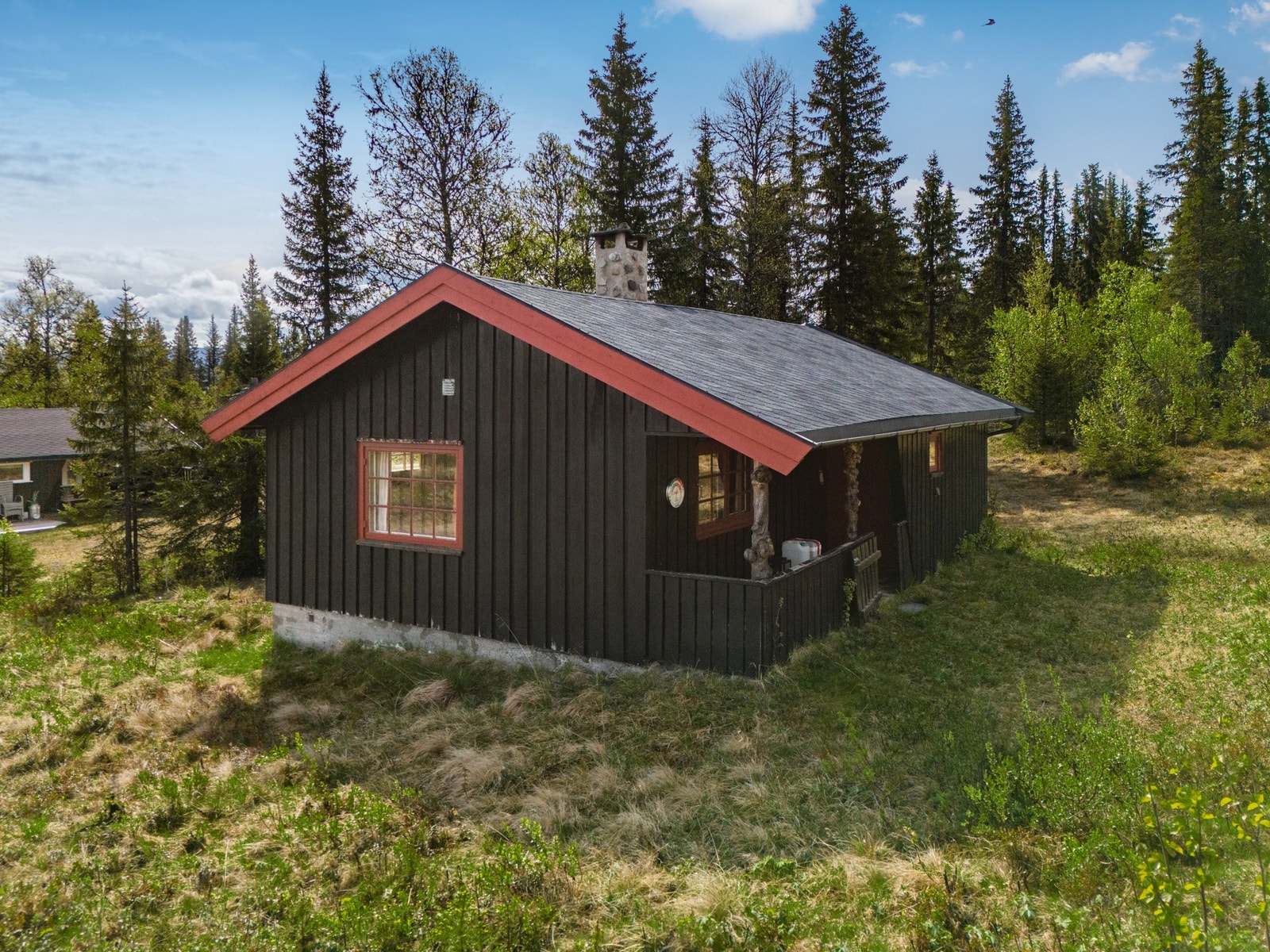 Hytta har en terrasoverbygget terrasse med plass til liten sittegruppe Galleribilde