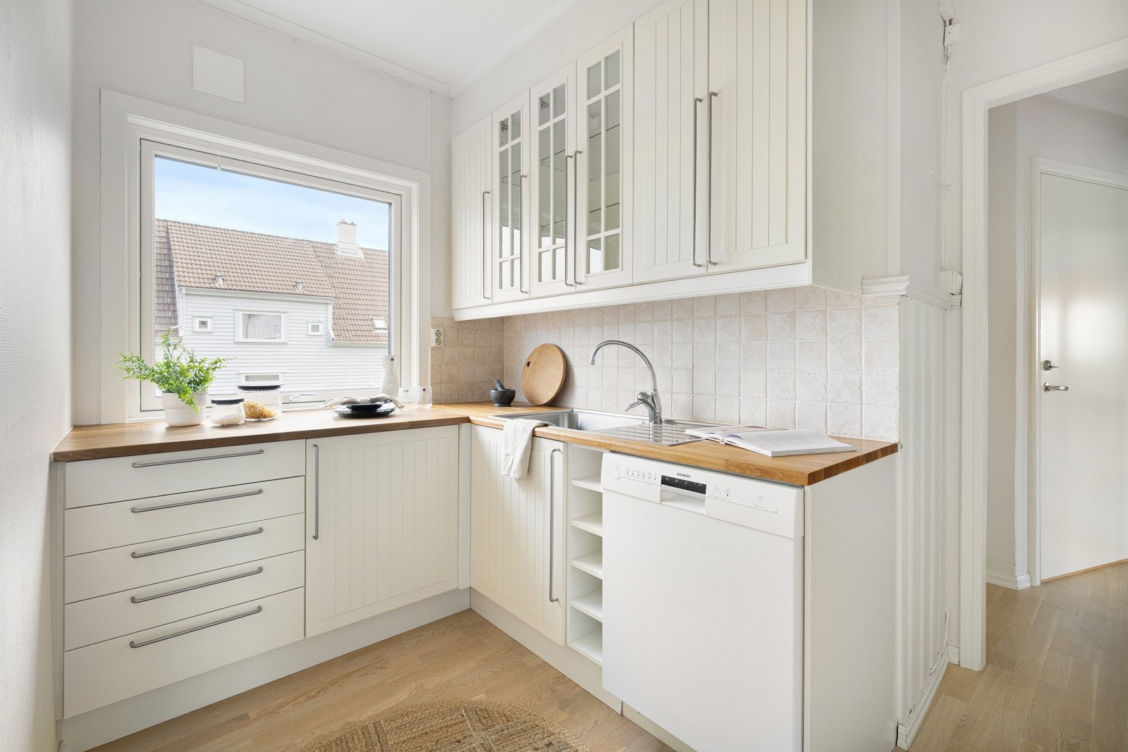 Kjøkkenet består av hvite, slette fronter med en trebenkeplate. Galleribilde