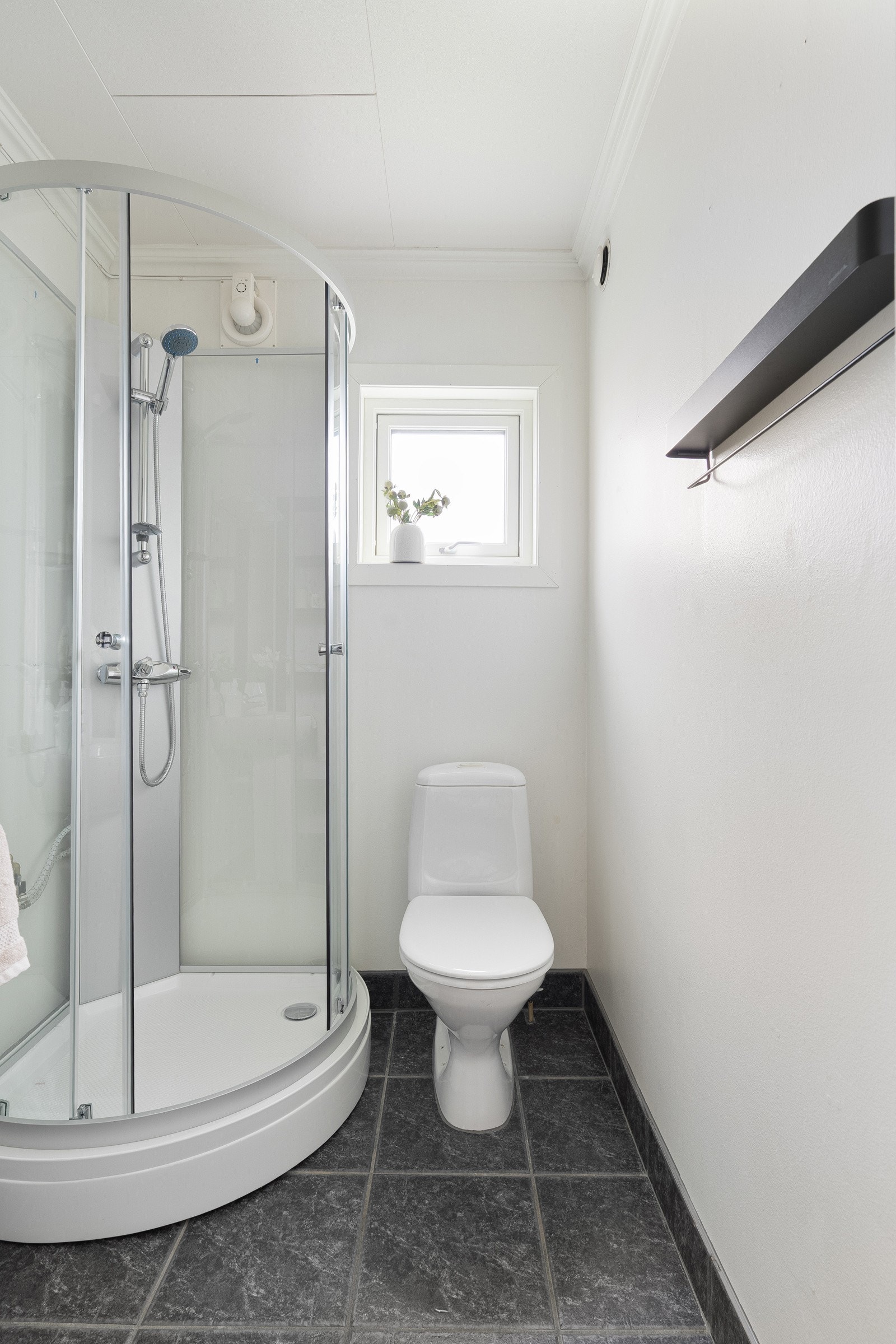 På gulvet er det lagt mørke fliser, og på veggene er det malte plater. Galleribilde