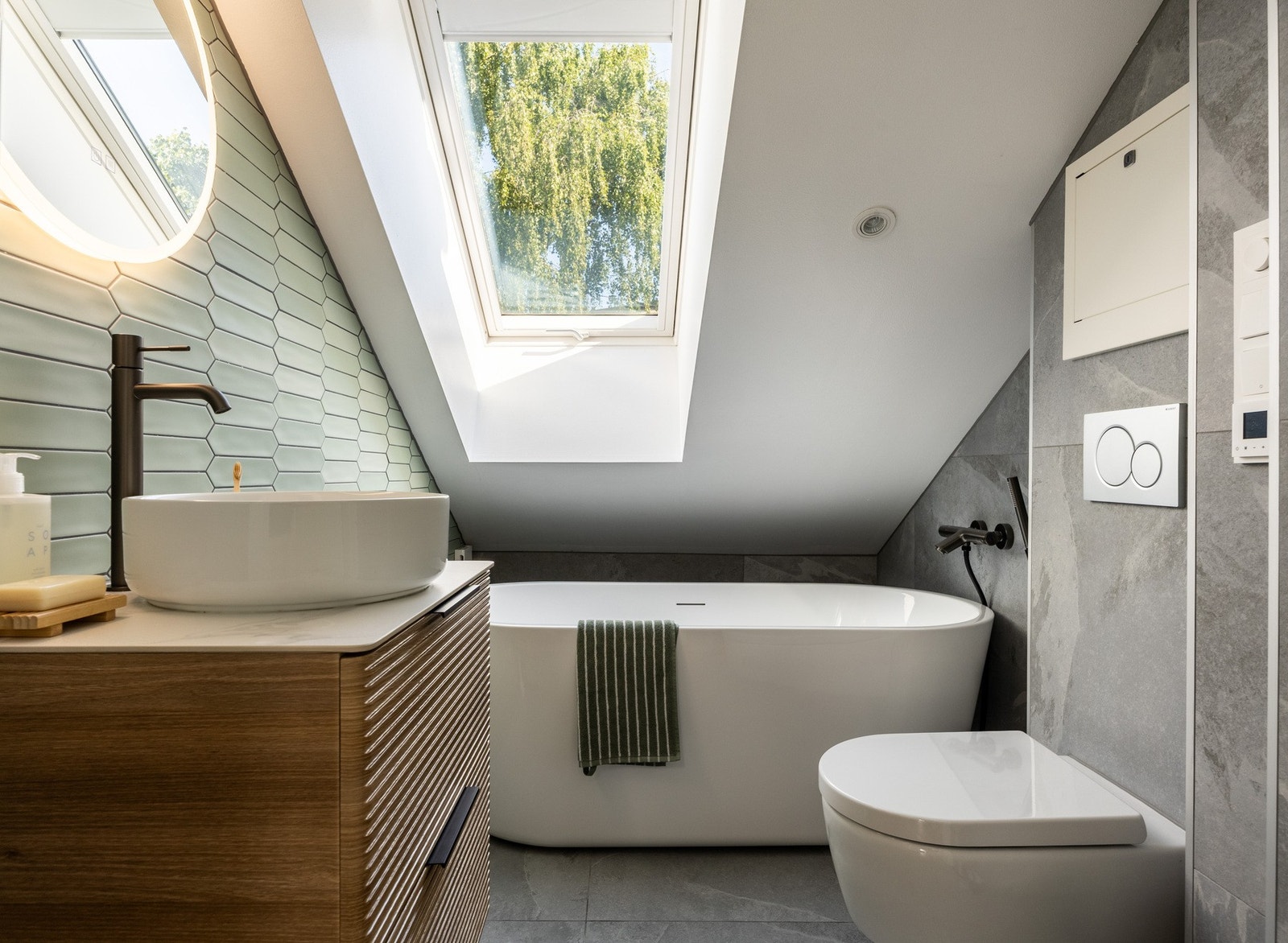 Baderom fra 2024 med flislagt gulv med gulvvarme og flislagte vegger. Galleribilde