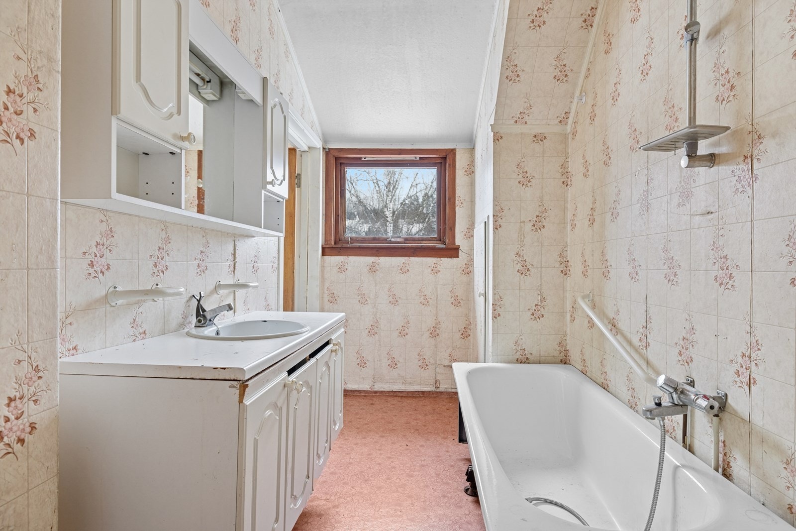 Badet ligger i boligens andre etasje og har vinylbelegg på gulv med oppbrett på vegg, våtromstapet på vegger og malte slette plater i himling. Galleribilde