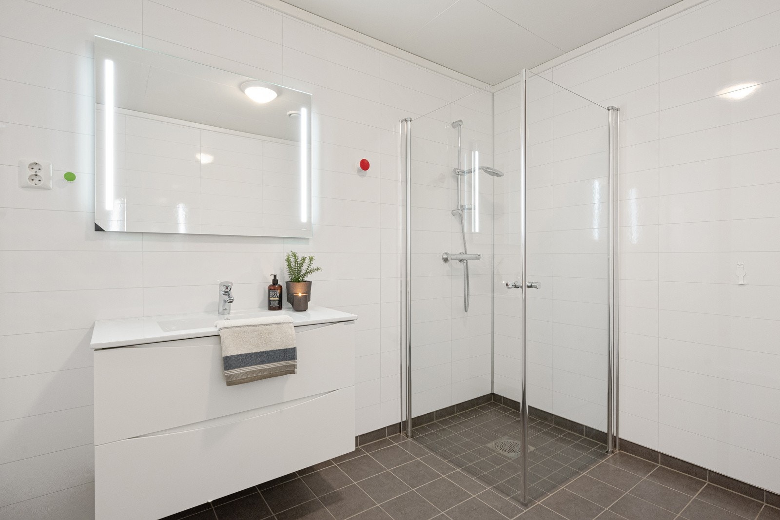 Tidløst bad med flislagte gulv, moderne baderomsplater på veggene og himlingsplater i taket. Galleribilde