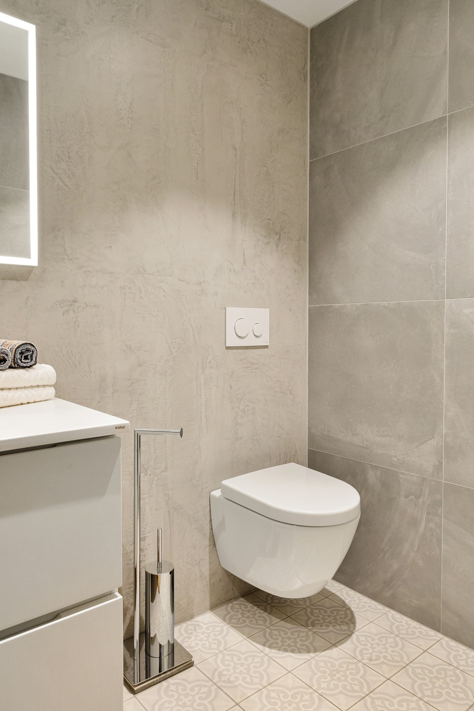 Videre i rommet finner du et stilrent, veggmontert toalett som harmonerer med resten av baderommets uttrykk. Galleribilde