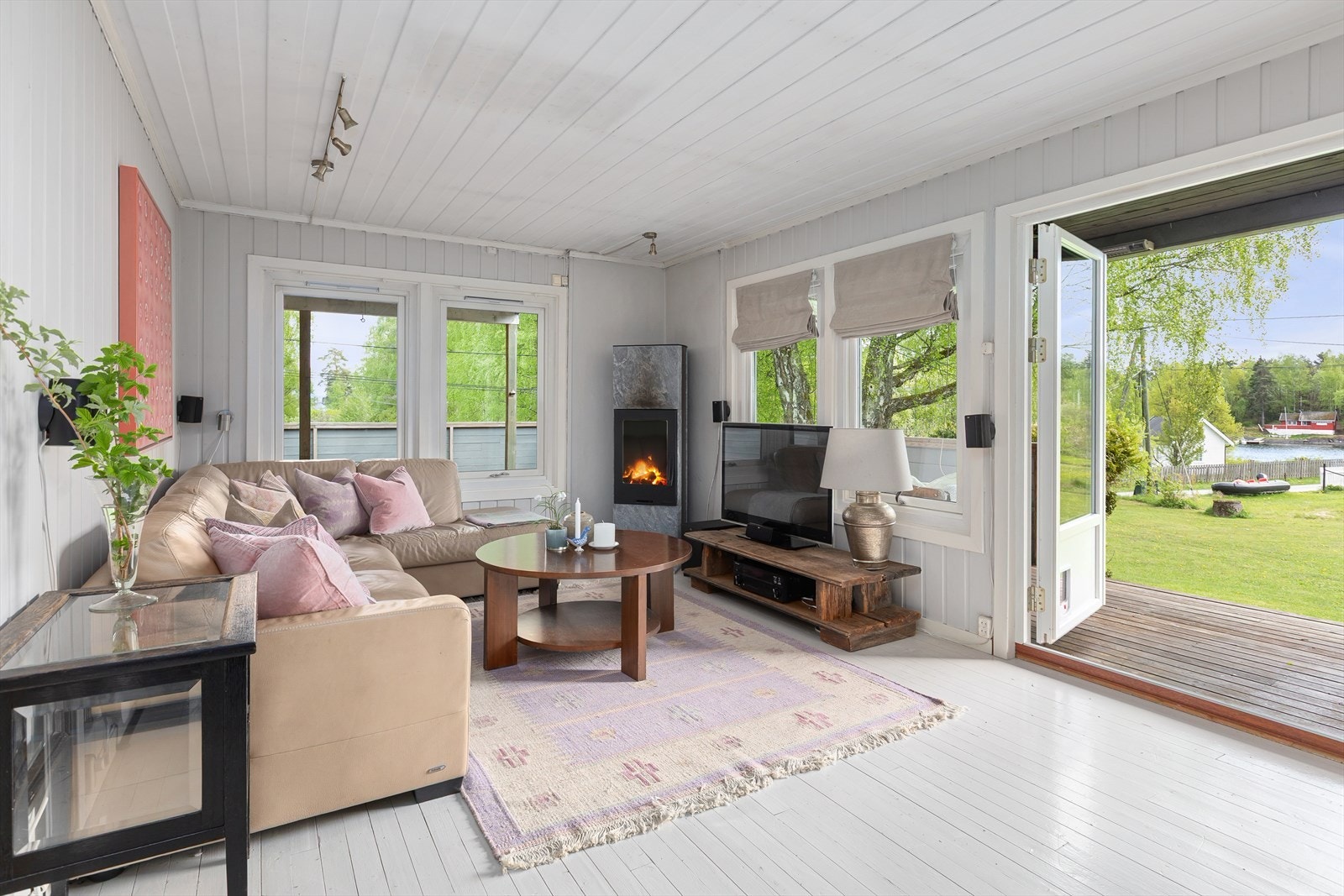 Lys og trivelig stue med god plass til sofagruppe. En vedovn bidrar med varme og hygge. Vedovnen er fra 2016 og er kledd med olivin stein fra Hanøl. Galleribilde