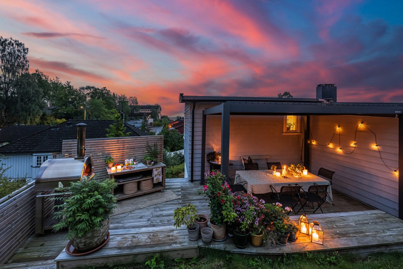 Skjermet platting på bakside av boligen med pergola og levegg Galleribilde