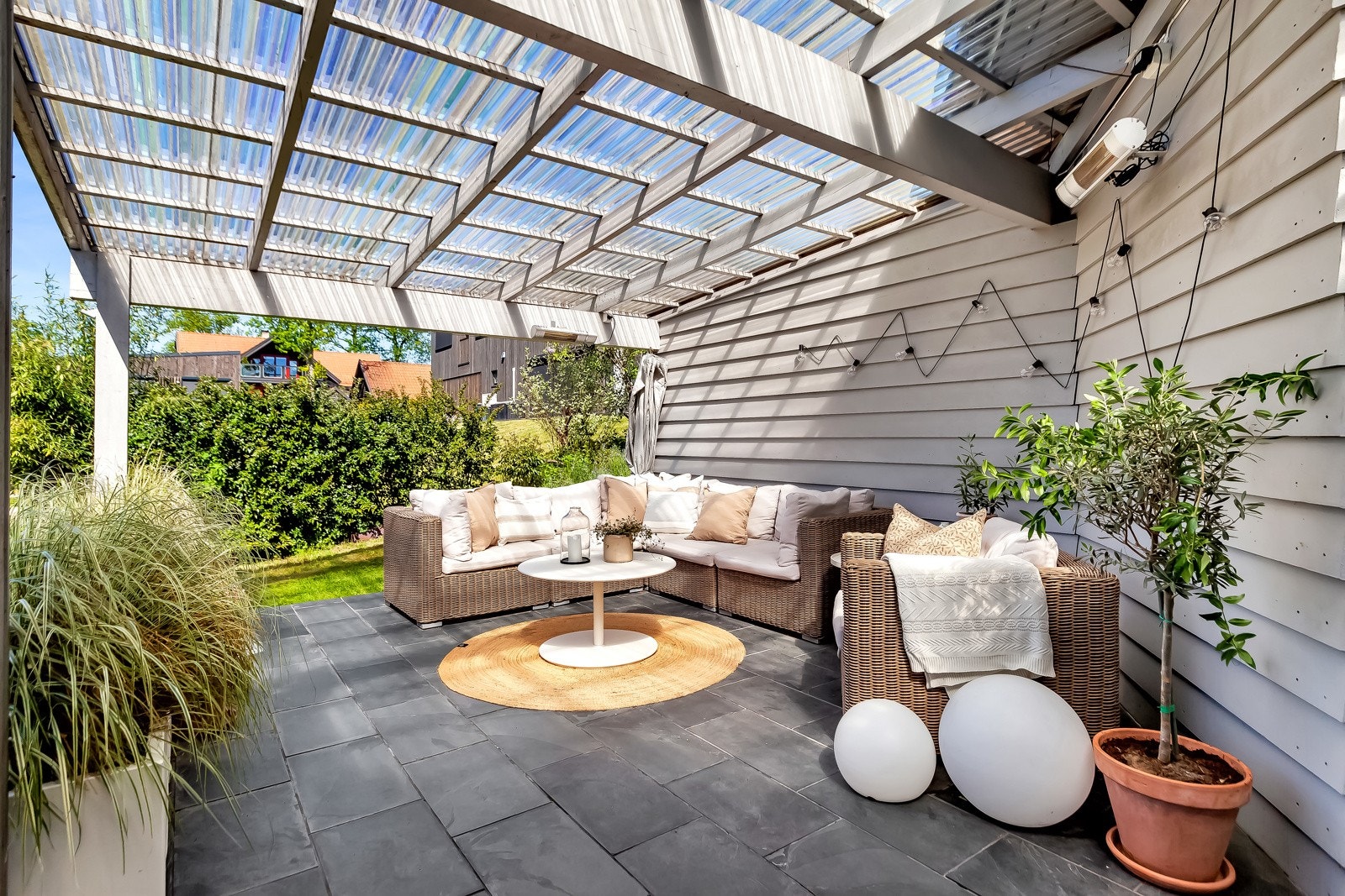 Flott uteplass under tak like utenfor døren. Her skinner solen til sent på kveld. Galleribilde