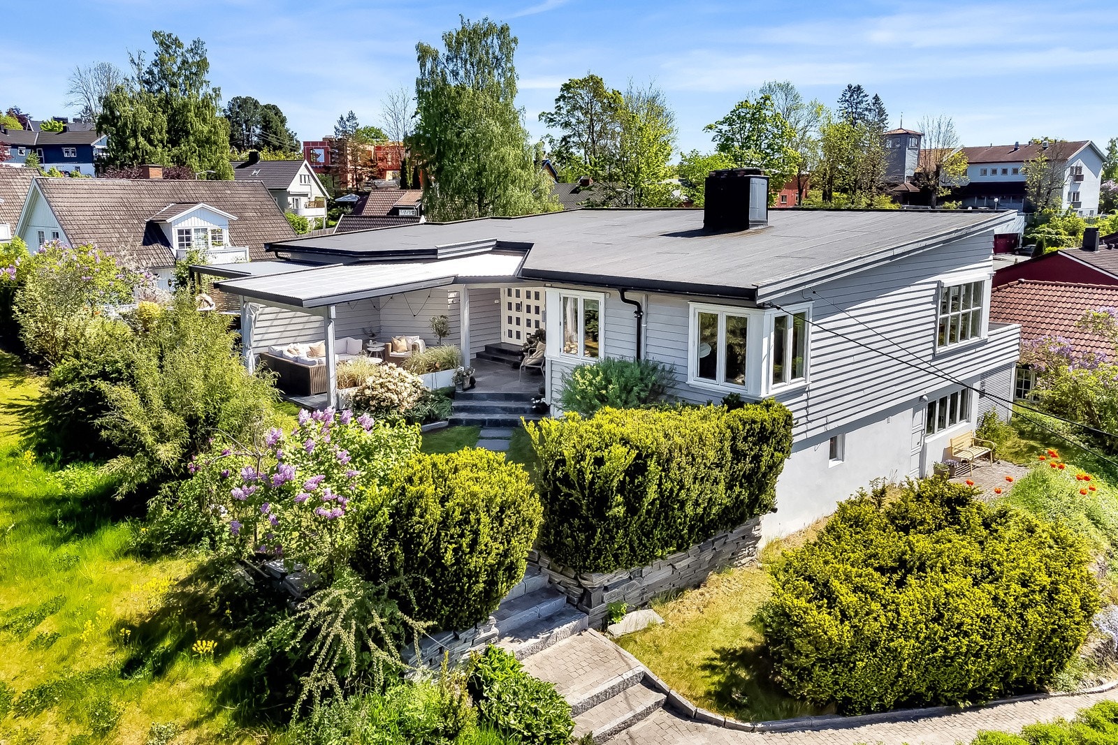 Godt etablert uteområde med en rekke prydbusker og blomster. Galleribilde