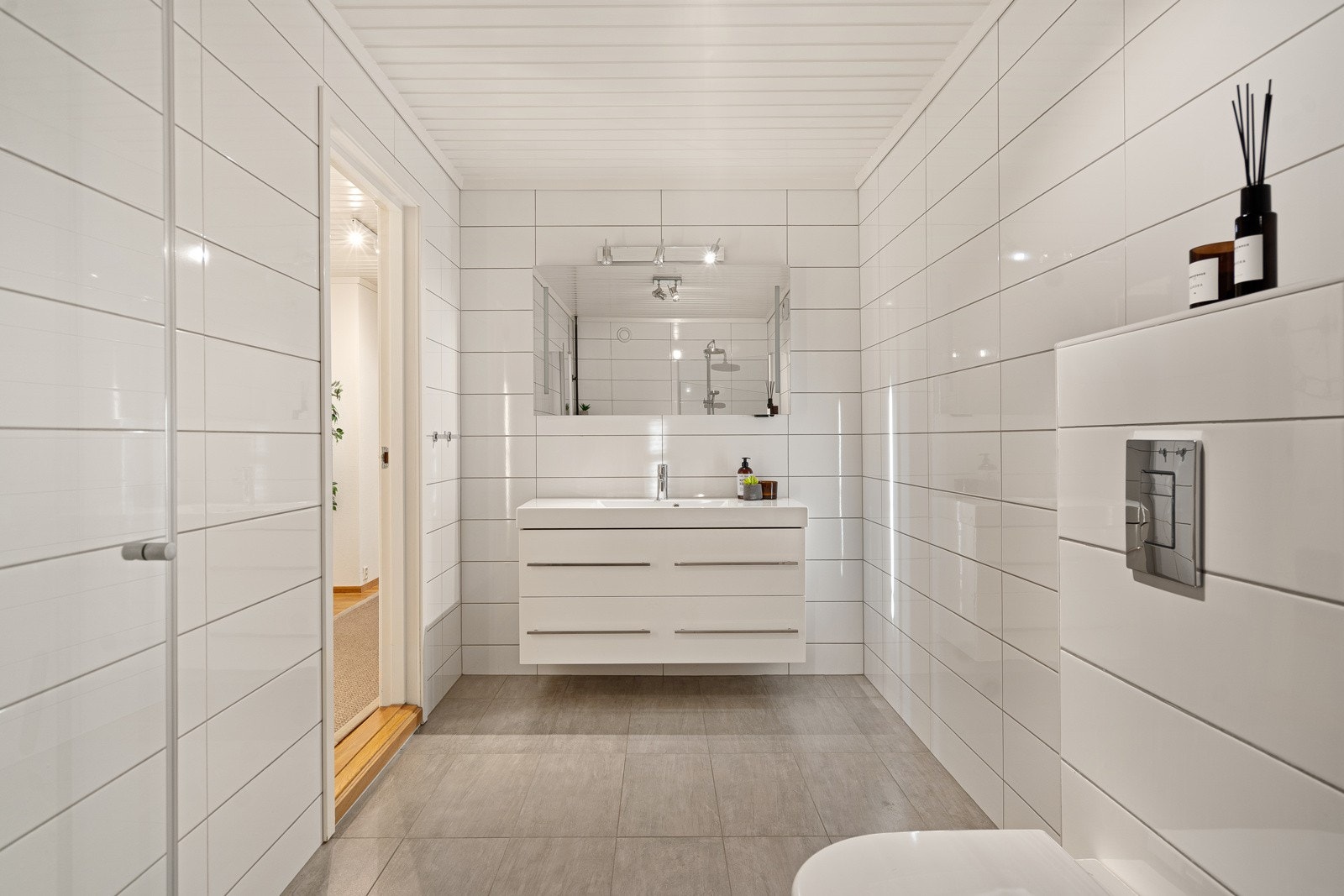 Baderommet i 1. etasje er romslig og helfliset. Det er innredet med dusj, vegghengt toalett og en stilfull servant Galleribilde