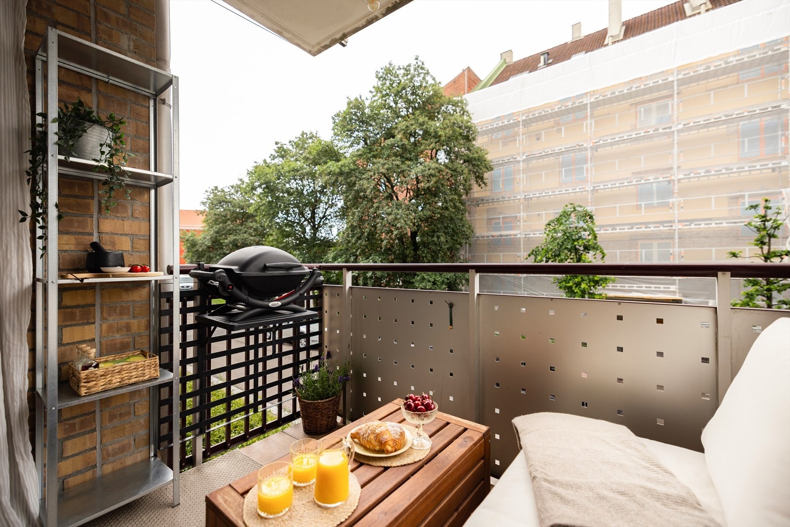 Hyggelig balkong med god plass til sittegruppe og grill med utsyn mot gate og grønne trær Galleribilde