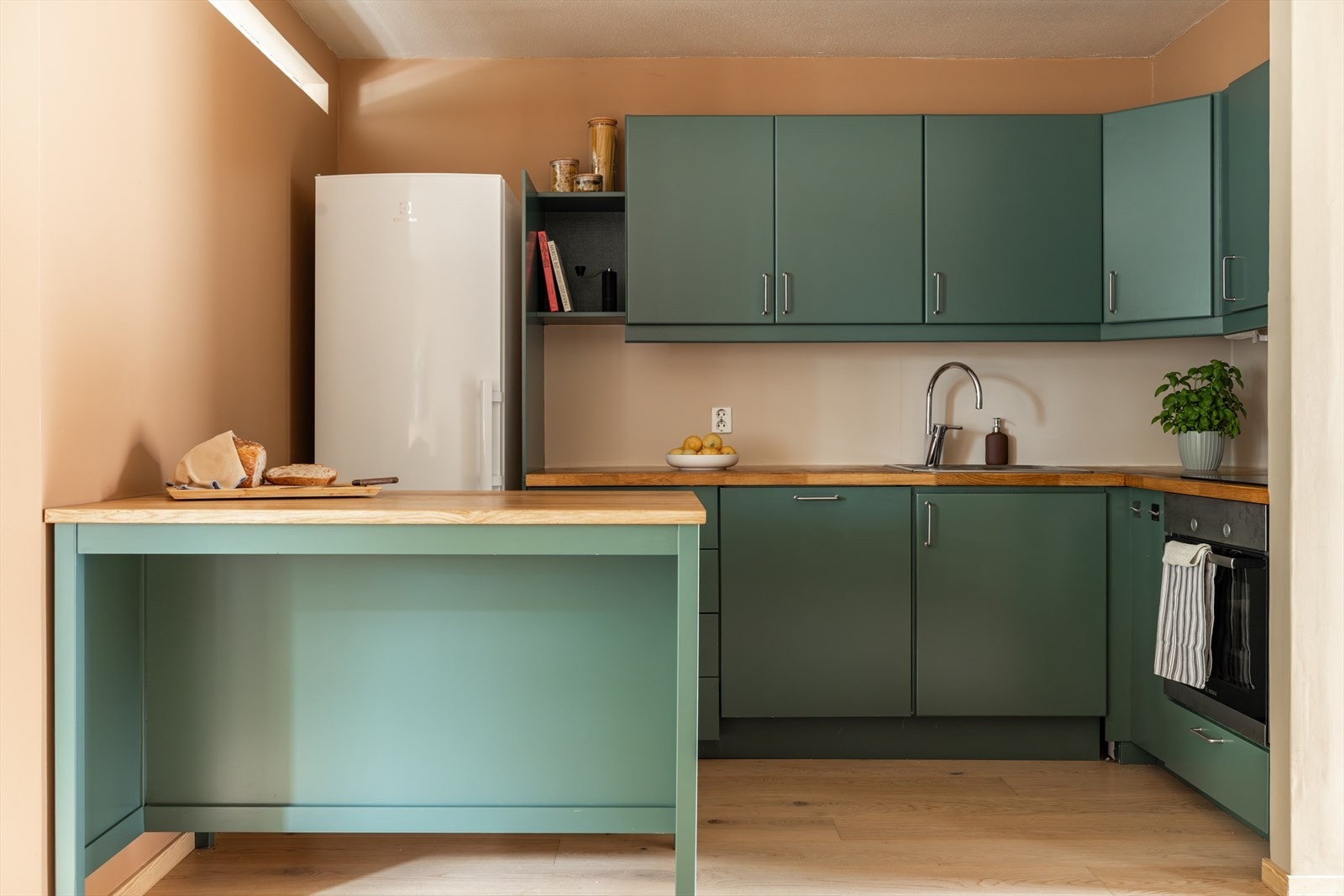 Sjarmerende kjøkken med grønne fronter, benkeplate i tre og god skapplass Galleribilde