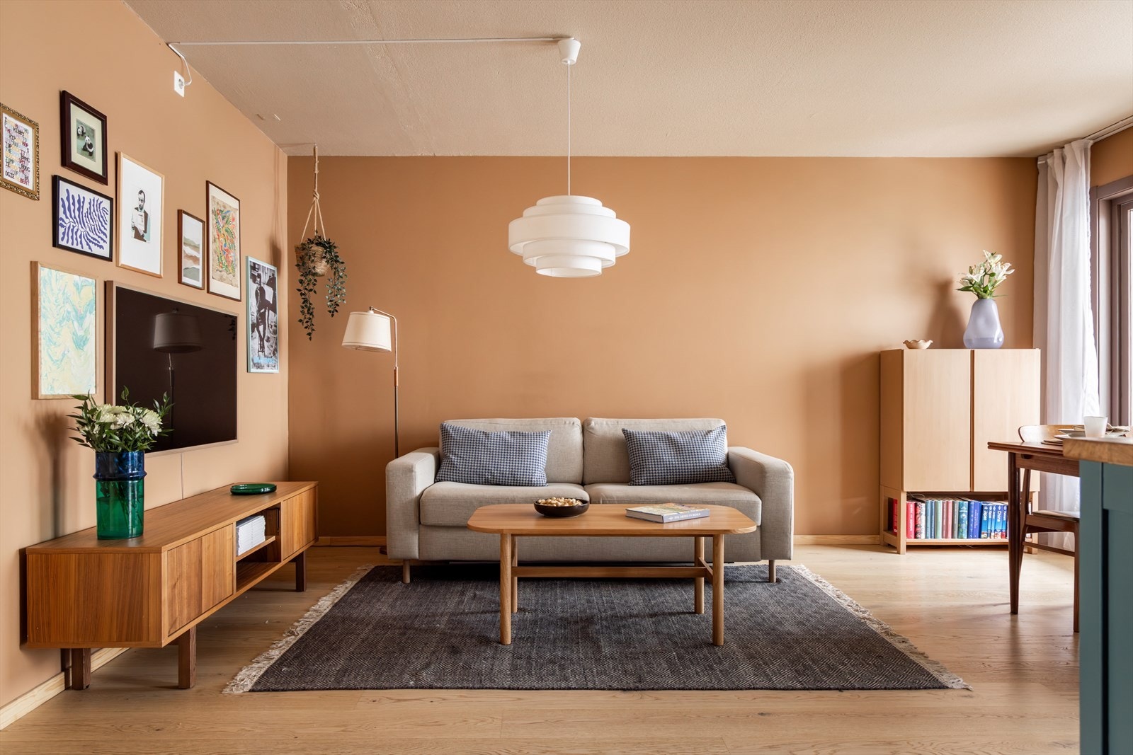 Lys og innbydende stue med lune fargetoner og flott parkettgulv Galleribilde