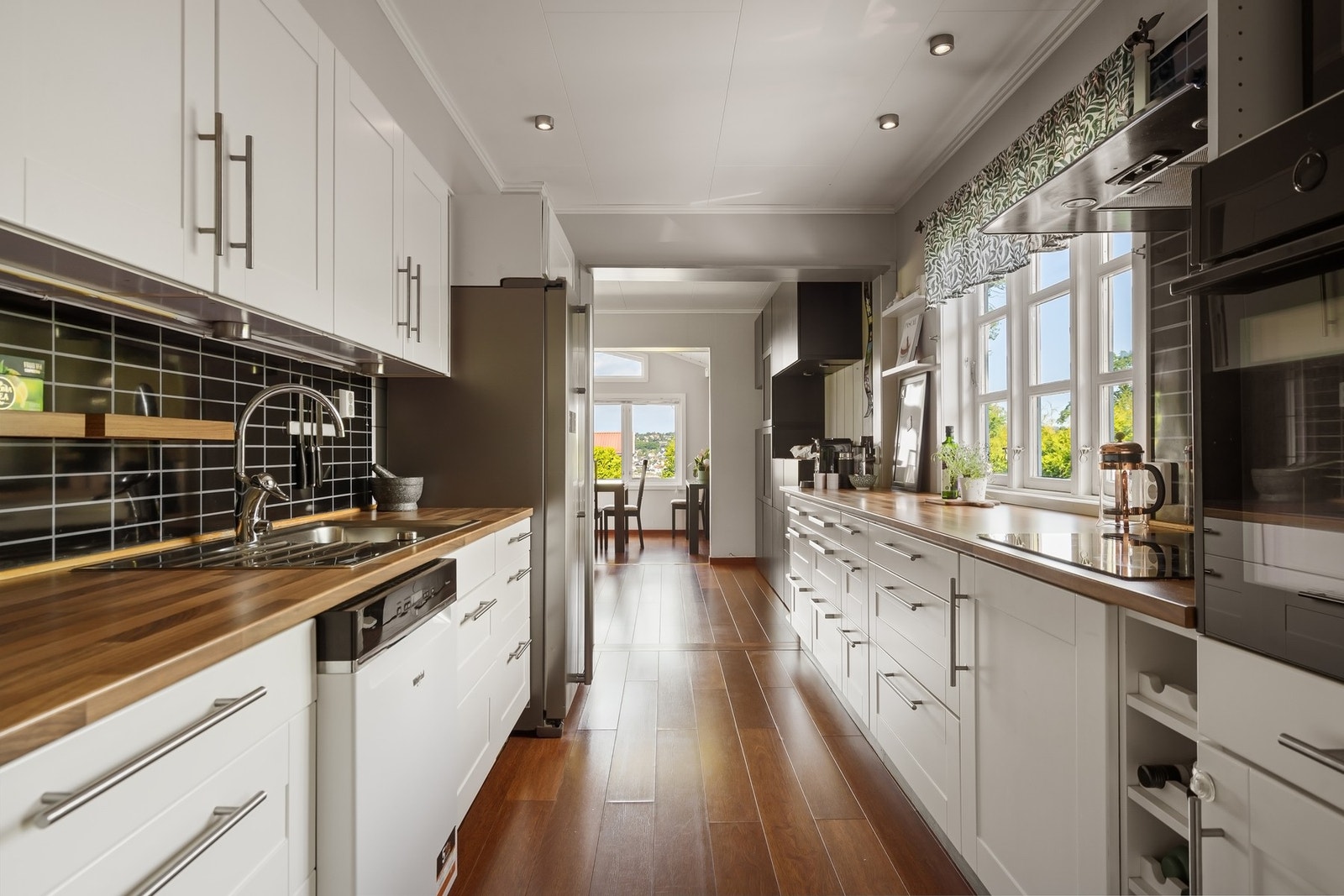 Pent kjøkken med godt av skap- og benkeplass Galleribilde