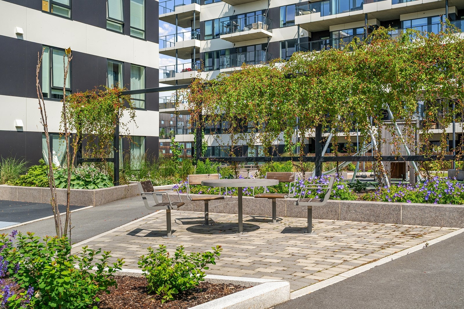 Fellesområde pent opparbeidet med felles tun. Asfaltert gangvei, lekeplass, grøntareal beplantet med plen bed og busker. Galleribilde